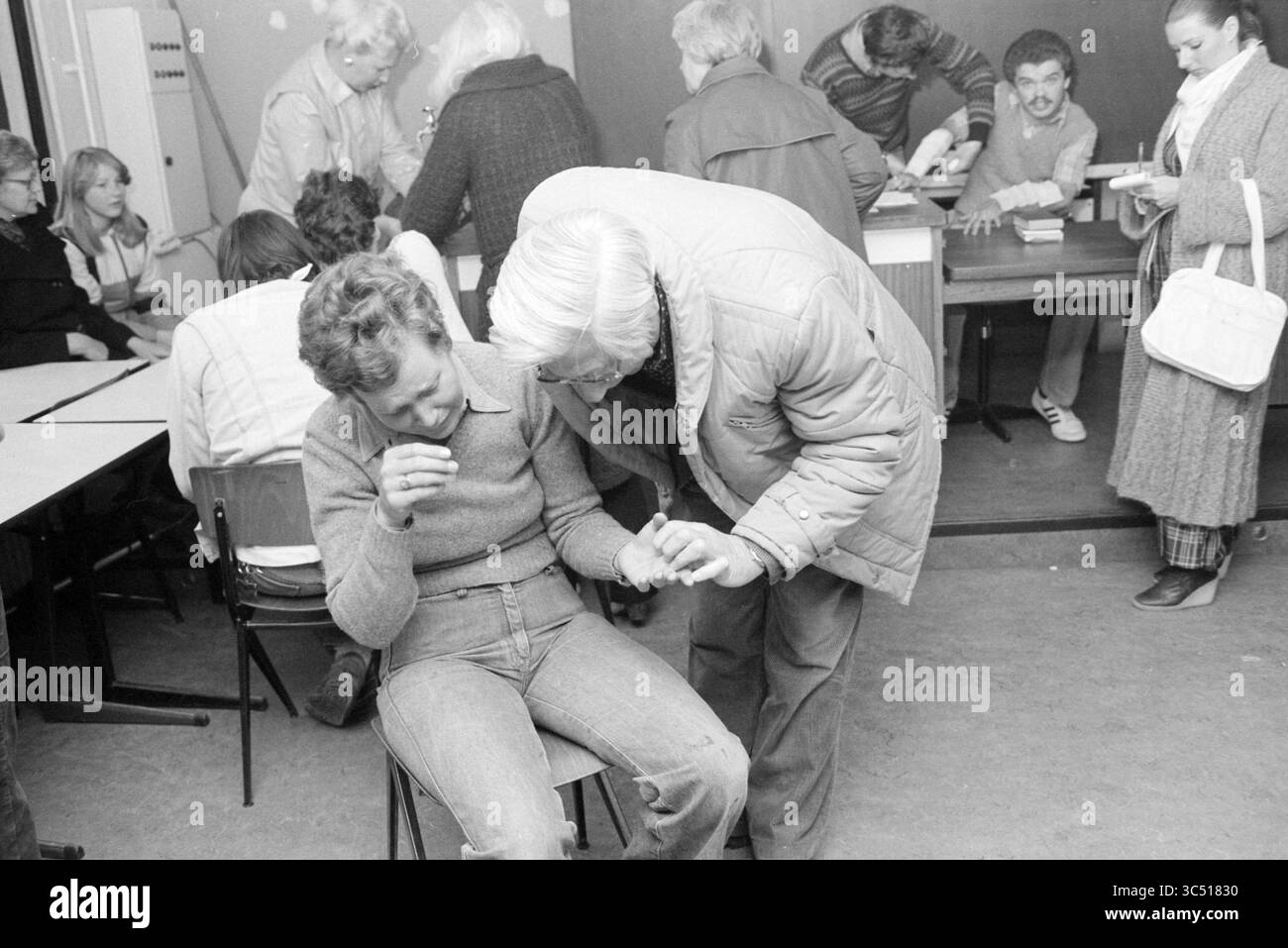 Esercitazione dei vigili del fuoco Heemstede, vigili del fuoco, Heemstede, Paesi Bassi, 21-04-1981 Whizgle News, Dutch Desk, Paesi Bassi, 1950-2000 Un gruppo di persone impegnate in varie attività, con un individuo seduto come un altro si appoggia per offrire supporto o guida. Nelle vicinanze, altri sono impegnati a tavola, contribuendo a creare un'atmosfera collaborativa. La scena cattura un mix di espressioni e interazioni tra i partecipanti. Foto Stock