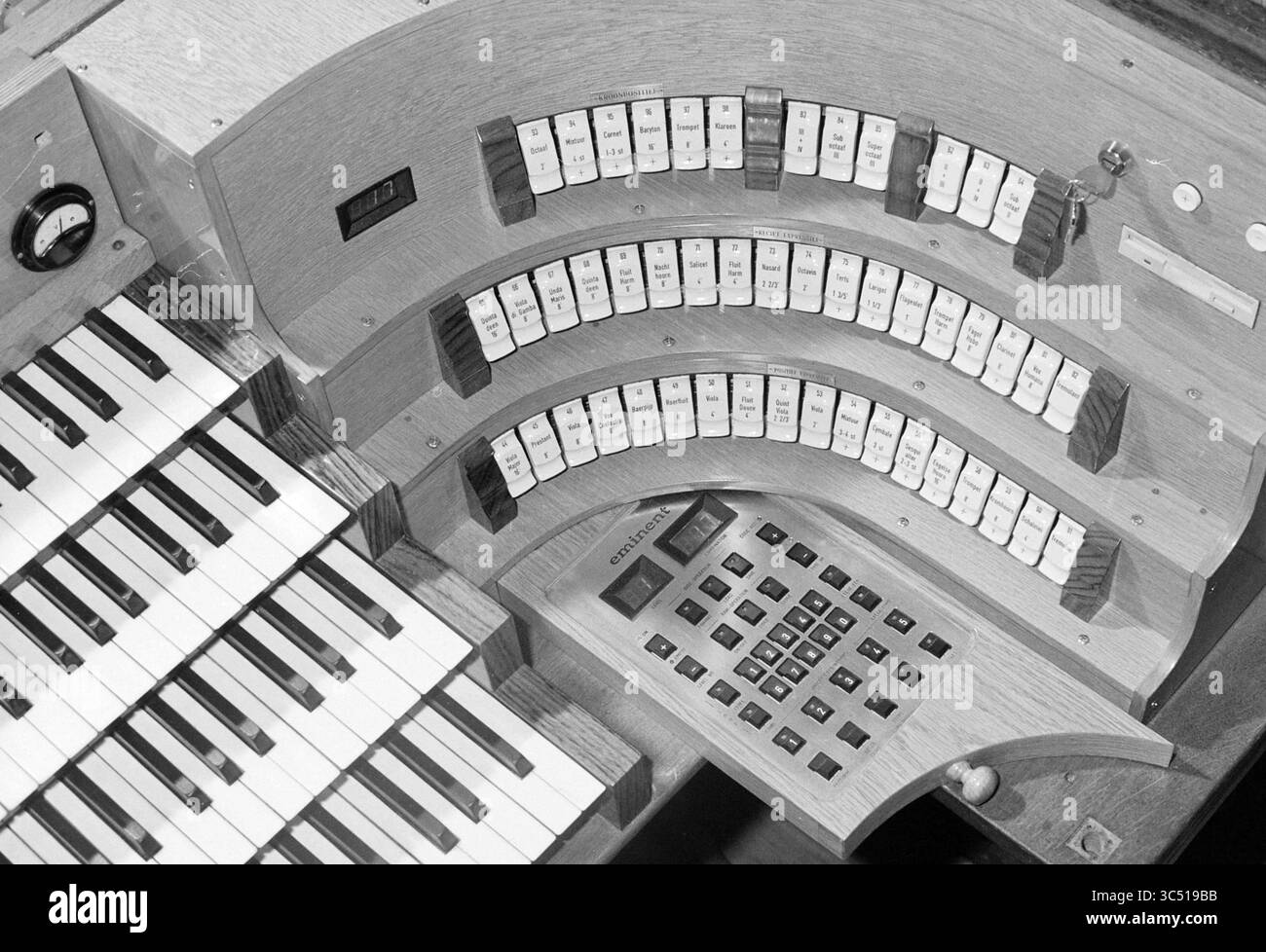 Nuovo organo Operation Bavo, 24-03-1995 Whizgle News, Dutch Desk, Paesi Bassi, 1950-2000 Uno strumento musicale d'epoca con una serie di tasti e pulsanti, disposti in un layout curvo. Lo strumento presenta una miscela di texture in legno e un pannello di controllo, suggerendone l'uso per produrre paesaggi sonori complessi. Foto Stock