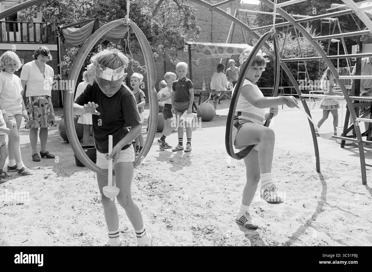 Parco giochi per famiglie, feste, giochi e giocattoli, Haarlem, Witte Herenstraat, paesi Bassi, 09-08-1984 Whizgle News, Dutch Desk, Paesi Bassi, 1950-2000 Un vivace parco giochi pieno di bambini che si divertono con varie attività. Alcuni bambini girano su sedili circolari mentre altri giocano sulla sabbia ed esplorano l'attrezzatura da arrampicata. Gli adulti sorvegliano le vicinanze, creando un'atmosfera allegra ed energica. Foto Stock