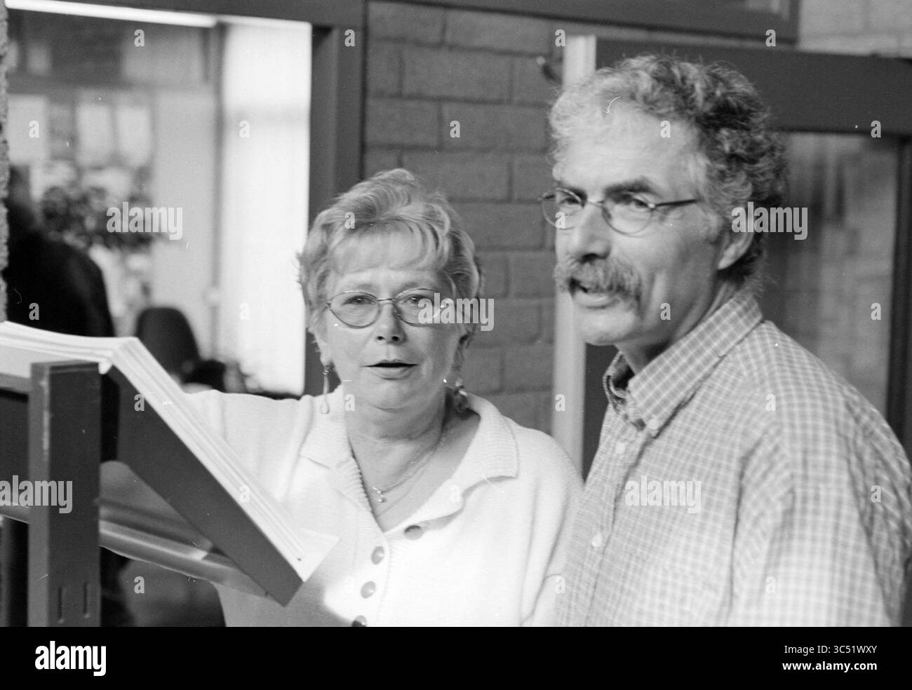 Peter e Martha, Howler, IJmuiden, IJmuiden, Paesi Bassi, 23-04-1997 Whizgle News, Dutch Desk, Paesi Bassi, 1950-2000 due persone si impegnano in conversazione, con una che indica un documento mentre l'altra ascolta attentamente. L'ambientazione suggerisce un ambiente informale, probabilmente incentrato sulla collaborazione o sulla discussione. Foto Stock