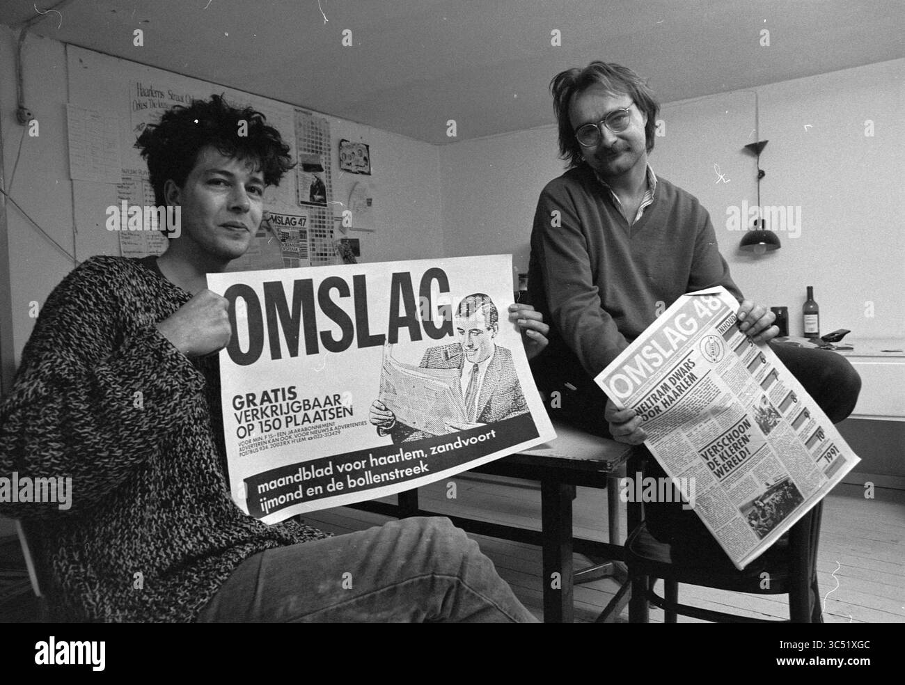 Copertina editoriale, Release, 10-01-1991 Whizgle News, Dutch Desk, Paesi Bassi, 1950-2000 due persone sono sedute a un tavolo, ciascuna con una pubblicazione intitolata "OMSLAAG". Uno mostra una grande versione della copertina, con il ritratto di un uomo, mentre l'altro contiene una copia che mostra vari articoli. L'ambientazione appare informale e creativa, suggerendo di concentrarsi sulle notizie locali o sugli eventi della comunità. Foto Stock