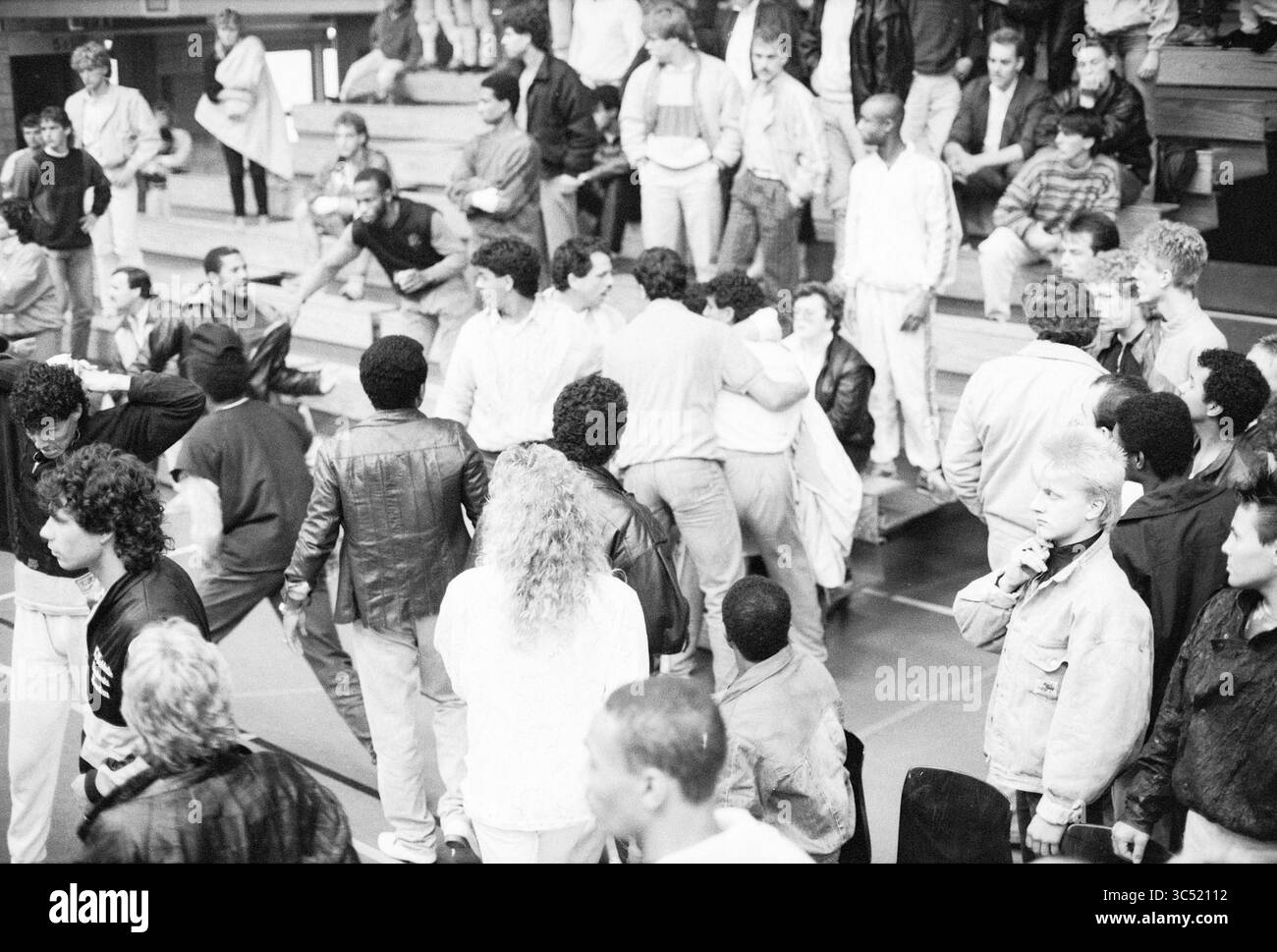 Thai boxing gala, pugilato, 07-06-1986 Whizgle News, Dutch Desk, Paesi Bassi, 1950-2000 Un vivace raduno di persone impegnate in conversazione e attività, con una folla diversificata che mostra vari stili ed espressioni. La scena cattura un momento di interazione e comunità in un ambiente spazioso. Foto Stock