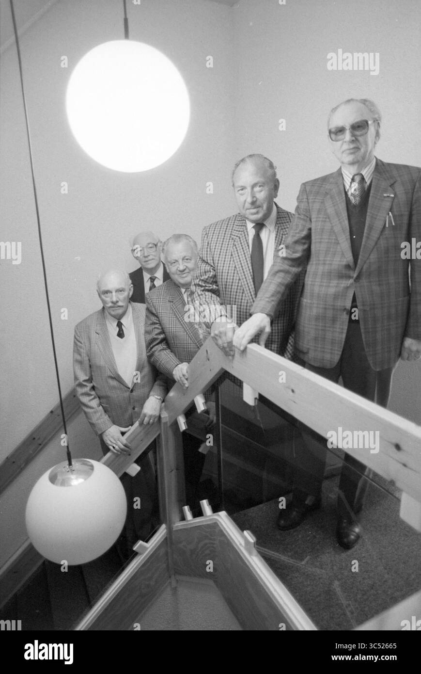 Casa dell'imprenditore sul Nieuwe Gracht a Haarlem, Haarlem, Nieuwe Gracht, Paesi Bassi, 13-04-1992 Whizgle News, Dutch Desk, Paesi Bassi, 1950-2000 Un gruppo di cinque illustri uomini si erge insieme su una scala, vestiti con abiti e cravatte, trasudando un senso di cameratismo e professionalità. L'ambiente è dotato di un grande sistema di illuminazione rotonda che aggiunge un tocco unico all'atmosfera. Foto Stock