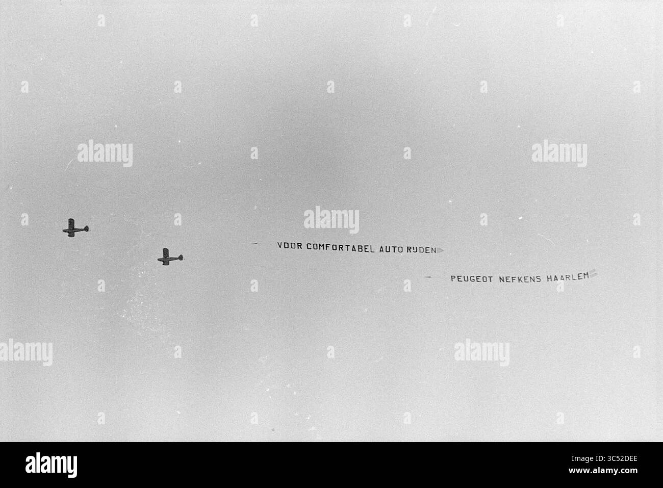 Aerial Advertising Company Nefkens, Aviation, Aerial Photographs, Advertising, 24-04-1976 Whizgle News, Dutch Desk, Paesi Bassi, 1950-2000 due aerei stanno volando in parallelo, trainando uno striscione che legge messaggi che promuovono comode corse in auto e una specifica concessionaria di automobili ad Haarlem. Foto Stock