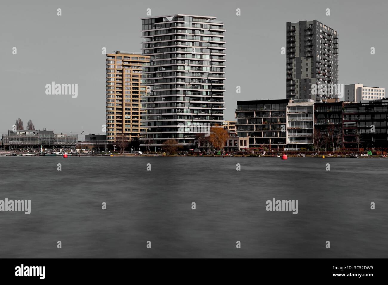La lunga esposizione dell'Amsteldijk De Pijp e del lungomare di Rivierenbuurt ad Amsterdam mostra torri sull'acqua liscia sotto il cielo umido, catturando la serenità. Foto Stock La lunga esposizione dell'Amsteldijk De Pijp e del lungomare di Rivierenbuurt ad Amsterdam mostra torri sull'acqua liscia sotto il cielo umido, catturando la serenità. Foto Stock