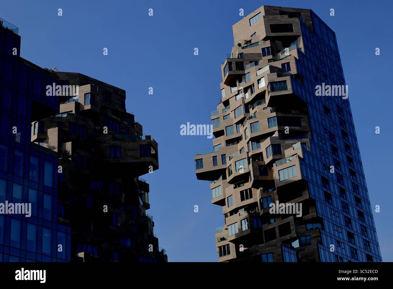 Le torri Twin Valley di Amsterdam si innalzano contro il cielo limpido, le loro terrazze a cascata e i balconi sfalsati che mostrano un'architettura moderna e innovativa. Foto Stock