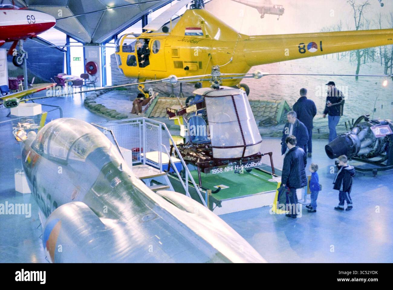 Aviodrome Schiphol, 00-01-2003 Whizgle News, Dutch Desk, Paesi Bassi, 1950-2000 una varietà di aerei in mostra in un museo, con un elicottero e un aereo militare, con visitatori di tutte le età che esplorano le mostre e apprezzano la storia dell'aviazione. Foto Stock