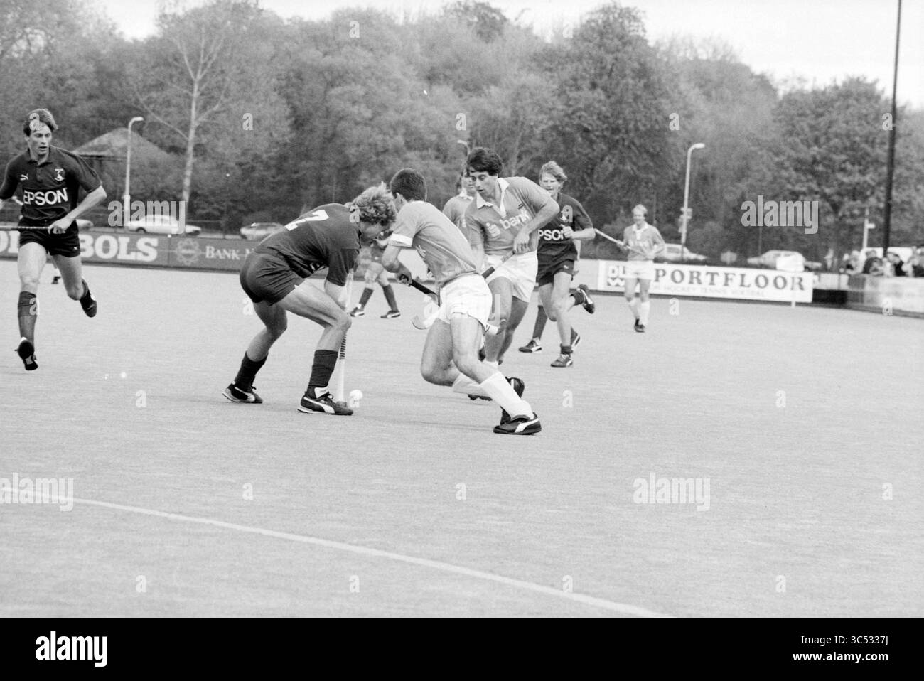 Bloemendaal - HCKZ, Hockey, Bloemendaal, 03-05-1987 Whizgle News, Dutch Desk, i Paesi Bassi, 1950-2000 Una scena dinamica di una partita di hockey in azione, con giocatori in piena marcia impegnati in una partita competitiva. Un giocatore manovra abilmente la palla, mentre gli avversari tentano di riconquistare il possesso. Sullo sfondo sono presenti alberi e spettatori che si aggiungono all'atmosfera dell'evento sportivo. Foto Stock
