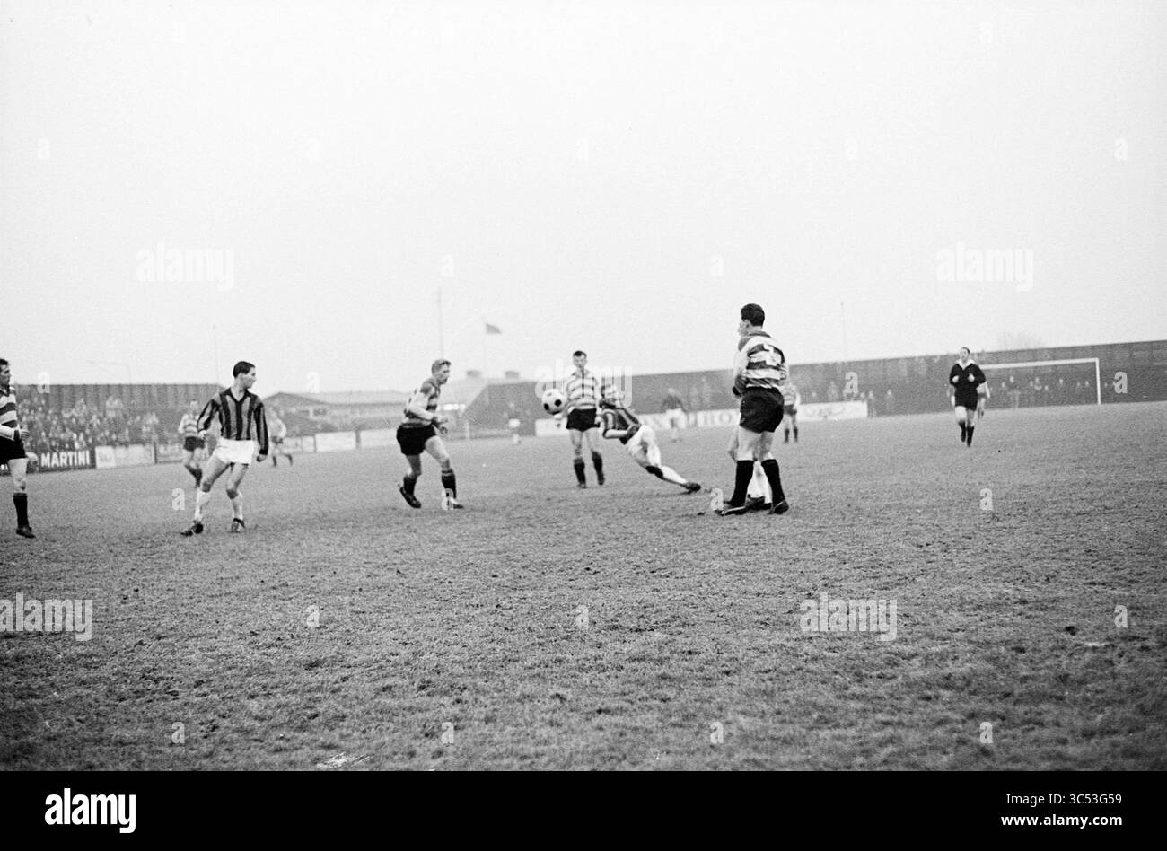 RCH - BE Quick, calcio, 05-01-1964 Whizgle News, Dutch Desk, Paesi Bassi, 1950-2000 Una scena dinamica su un campo da calcio, dove i giocatori con maglie a strisce sono impegnati in una partita intensa. Un giocatore tenta abilmente di passare la palla mentre i compagni di squadra e gli avversari si mettono in posizione per la partita successiva. L'atmosfera trasmette un senso di eccitazione e competizione, con spettatori distanti che guardano l'azione che si svolge. Foto Stock