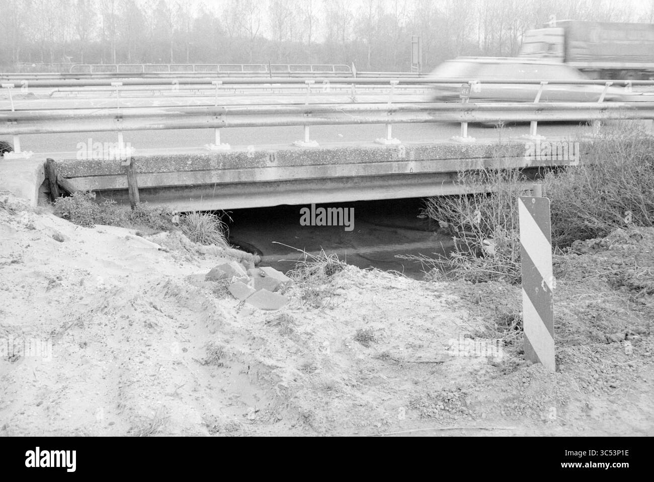 Tunnel, Oostlaan, V'broek, Velserbroek, Oostlaan, 24-10-1990 Whizgle News, Dutch Desk, Paesi Bassi, 1950-2000 Un sottopassaggio parzialmente oscurato sotto un'autostrada trafficata, incorniciato da pennello e ghiaia, mentre un veicolo accelera dalla testa. Foto Stock