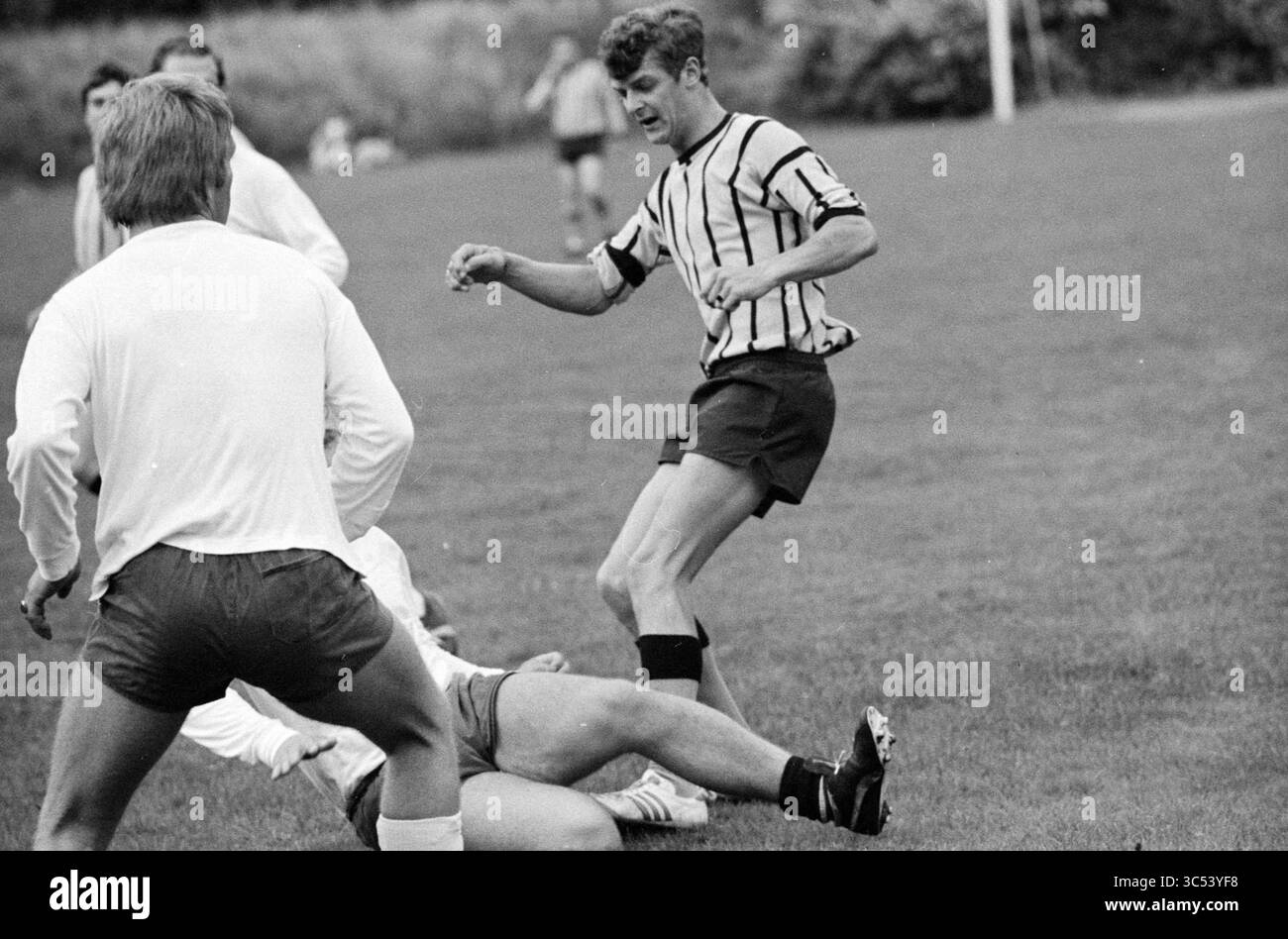Polizia - English Soldiers, Football, 08-08-1973 Whizgle News, Dutch Desk, Paesi Bassi, 1950-2000 Un momento dinamico sul campo di calcio cattura un giocatore in una scena intensa mentre naviga attraverso un groviglio di avversari. La sua espressione concentrata e la sua posizione determinata mettono in risalto lo spirito competitivo del gioco, mentre i compagni di squadra si impegnano nella mischia nelle vicinanze. Foto Stock