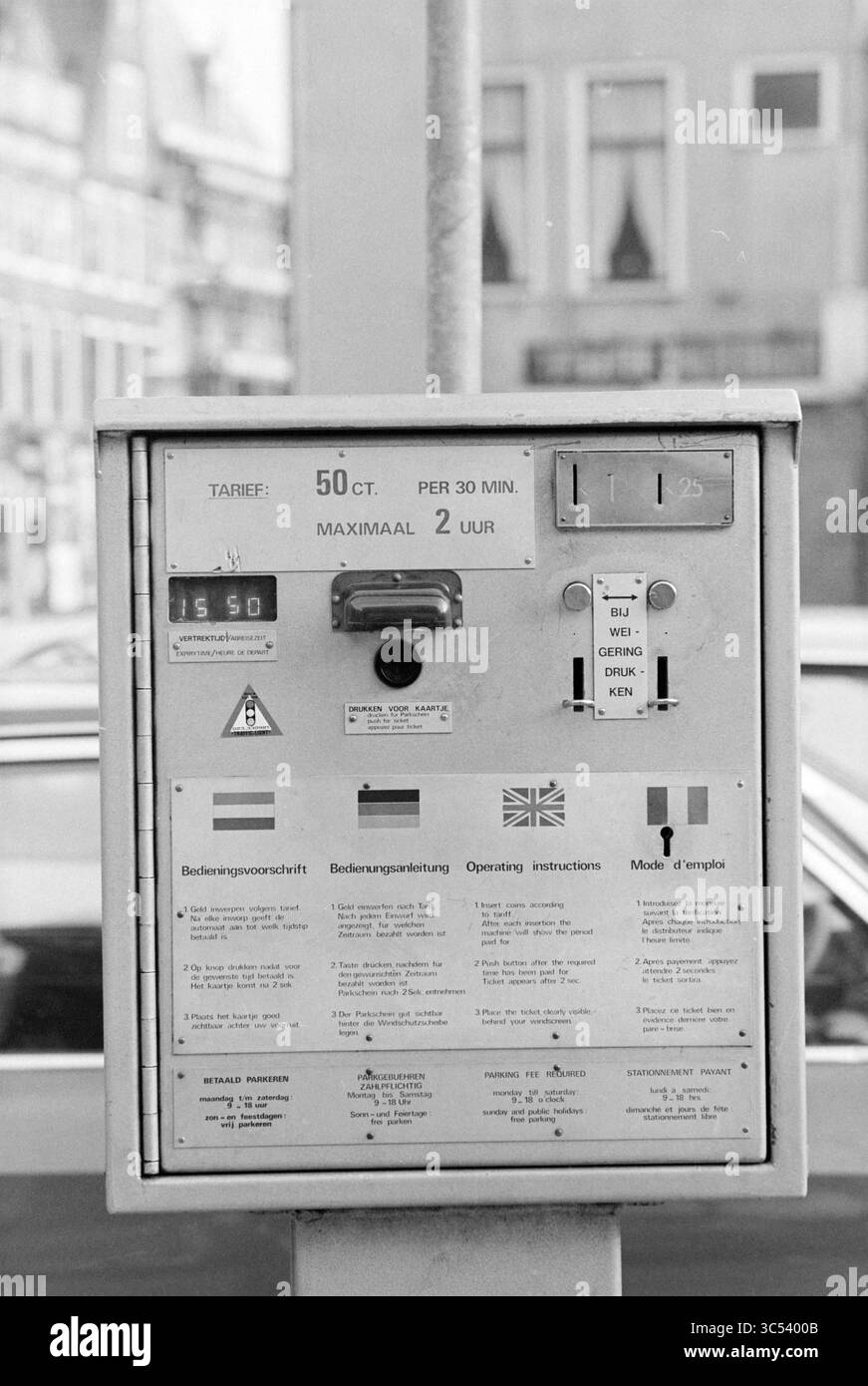 Parchimetro, 00-02-1980 Whizgle News, Dutch Desk, Paesi Bassi, 1950-2000 Una macchina per il pagamento del parcheggio con istruzioni in più lingue, informazioni dettagliate sulle tariffe di pagamento e linee guida operative. Vengono visualizzati vari simboli e flag per aiutare gli utenti a navigare nel processo di pagamento. Foto Stock