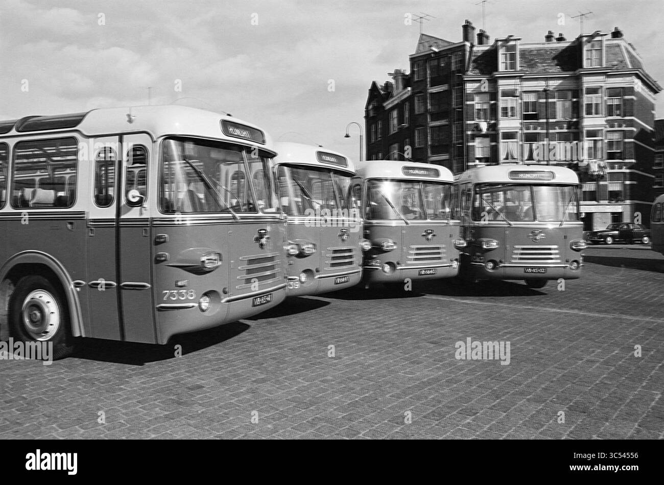 Nuovi autobus turistici per l'NZH a Houtplein, Haarlem, Houtplein, Paesi Bassi, 09-10-1963 Whizgle News, Dutch Desk, Paesi Bassi, 1950-2000 Una linea di autobus d'epoca si trova fianco a fianco, mostrando il loro design distinto e il loro fascino retrò sullo sfondo di un edificio cittadino. La scena cattura un momento nel tempo, evidenziando i trasporti pubblici di un'epoca passata. Foto Stock