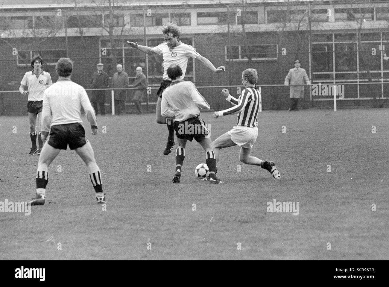 Waterloo - KHFC, Football, 12-04-1981 Whizgle News, Dutch Desk, Paesi Bassi, 1950-2000 Una partita di calcio dinamica cattura un giocatore che salta sopra un avversario, evitando abilmente un tackle mentre altri si impegnano nel gioco. La scena vede gli atleti in azione, con gli spettatori che guardano da dietro le quinte. Foto Stock