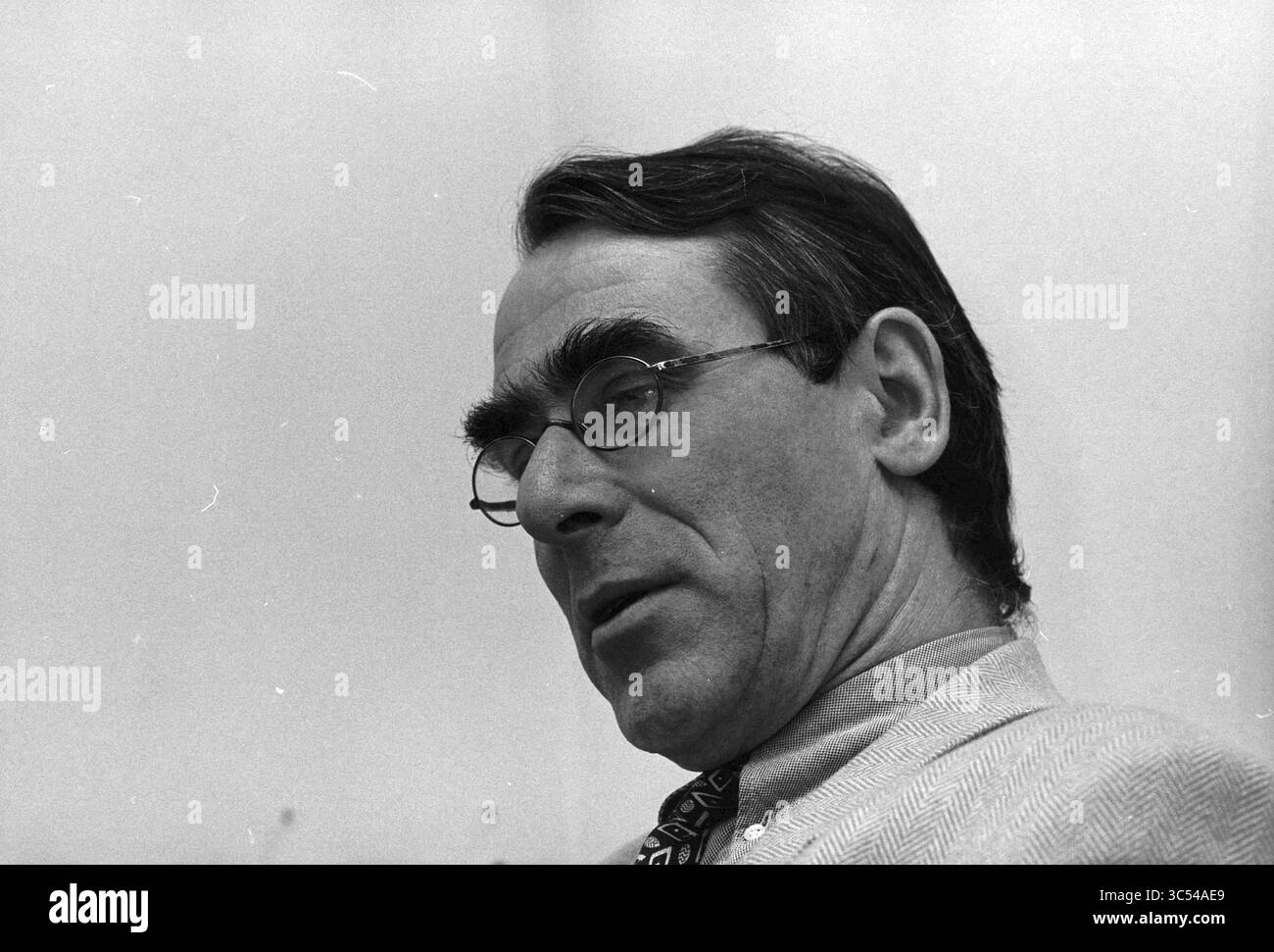 Sig. Verstraaten, PWN, Bloemendaal, Bloemendaal, 17-11-1997 Whizgle News, Dutch Desk, Paesi Bassi, 1950-2000 Un uomo dalle caratteristiche e dagli occhiali distintivi viene catturato in una posa premurosa, mostrando la sua espressione seria e i suoi capelli con uno stile impeccabile. Indossa un vestito e una cravatta a motivi, suggerendo un ambiente formale o un'occasione. Foto Stock