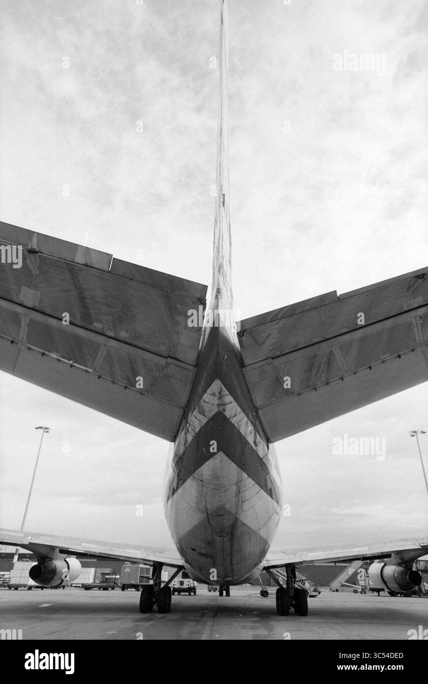 Aereo nigeriano, Schiphol, Schiphol, 20-10-1991 Whizgle News, Dutch Desk, i Paesi Bassi, 1950-2000 la coda di un grande aereo commerciale incombe in alto, mostrando il suo design elegante e gli stabilizzatori orizzontali di spicco. Lo sfondo presenta un vasto cielo, che indica la prontezza dell'aereo al decollo o all'atterraggio in un ambiente aeroportuale industriale. Foto Stock
