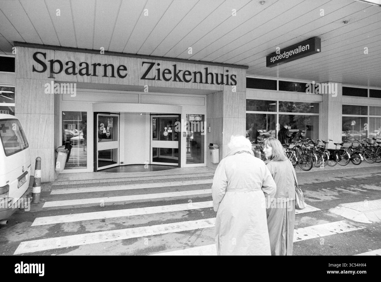 Anziani all'ospedale, Haarlem, Paesi Bassi, 20-09-1995 Whizgle News, Dutch Desk, i Paesi Bassi, 1950-2000 due persone si trovano all'ingresso di un ospedale chiamato "Spaarne Ziekenhuis", con biciclette parcheggiate nelle vicinanze e segnaletica che indica un pronto soccorso. Foto Stock