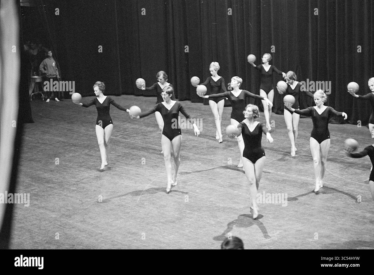 Serata di gala K.N.G.V., ginnastica, 15-03-1968 Whizgle News, Dutch Desk, Paesi Bassi, 1950-2000 Un gruppo di ballerini si esibisce a ritmo sincronizzato, ognuno con una palla mentre mostra i loro movimenti coordinati sul palco. Indossano un abbigliamento da ballo nero coordinato, trasudando eleganza e precisione mentre catturano il pubblico. Foto Stock