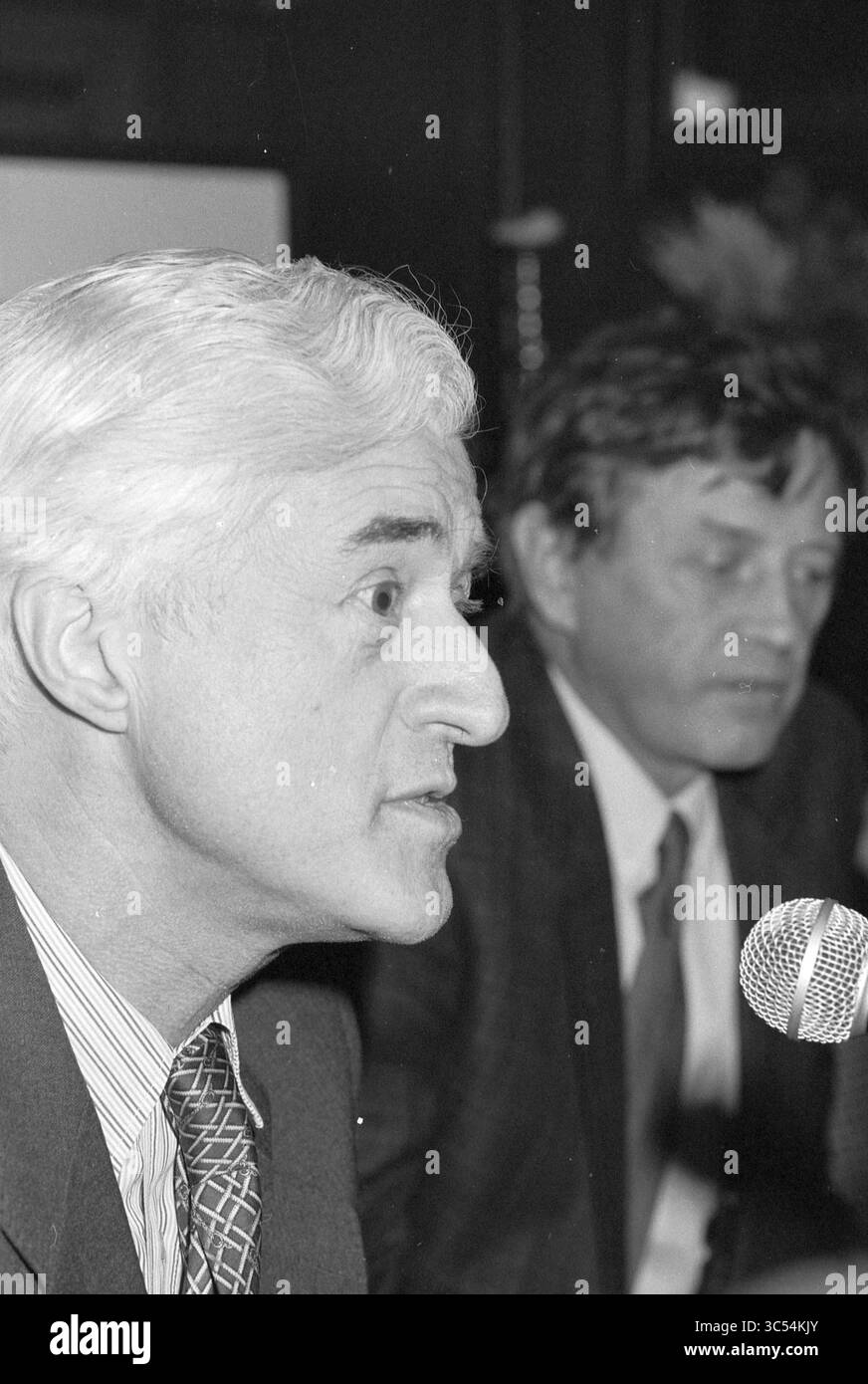 Political Café Vreeburg, Bloemendaal, Bloemendaal, 15-02-1994 Whizgle News, Dutch Desk, i Paesi Bassi, 1950-2000 due persone si sono impegnate in una discussione in una conferenza o in un panel, con una persona che parla intensamente in un microfono mentre l'altra ascolta attentamente. L'ambientazione appare formale, suggerendo un ambiente professionale o accademico. Foto Stock