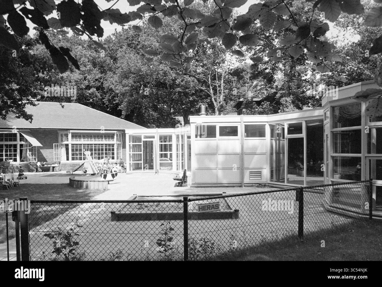 Centro diurno esterno Panda Santpoort, Santpoort, 17-07-1994 Whizgle News, Dutch Desk, Paesi Bassi, 1950-2000 Un moderno spazio esterno caratterizzato da una serie di strutture trasparenti, circondate dal verde e da una recinzione. L'area dispone di disposizione dei posti a sedere e di un ambiente tranquillo, ideale per il relax e le riunioni. Foto Stock Centro diurno esterno Panda Santpoort, Santpoort, 17-07-1994 Whizgle News, Dutch Desk, Paesi Bassi, 1950-2000 Un moderno spazio esterno caratterizzato da una serie di strutture trasparenti, circondate dal verde e da una recinzione. L'area dispone di disposizione dei posti a sedere e di un ambiente tranquillo, ideale per il relax e le riunioni. Foto Stock