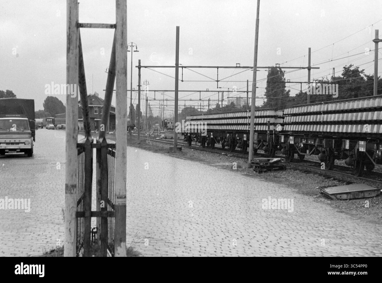Cantiere di smistamento, Westergracht, Sites, Haarlem, Westergracht, paesi Bassi, 19-09-1979 Whizgle News, Dutch Desk, Paesi Bassi, 1950-2000 Un cantiere con file di binari ferroviari disposti lungo una strada acciottolata, con veicoli e pali visibili sullo sfondo sotto un cielo coperto. Foto Stock