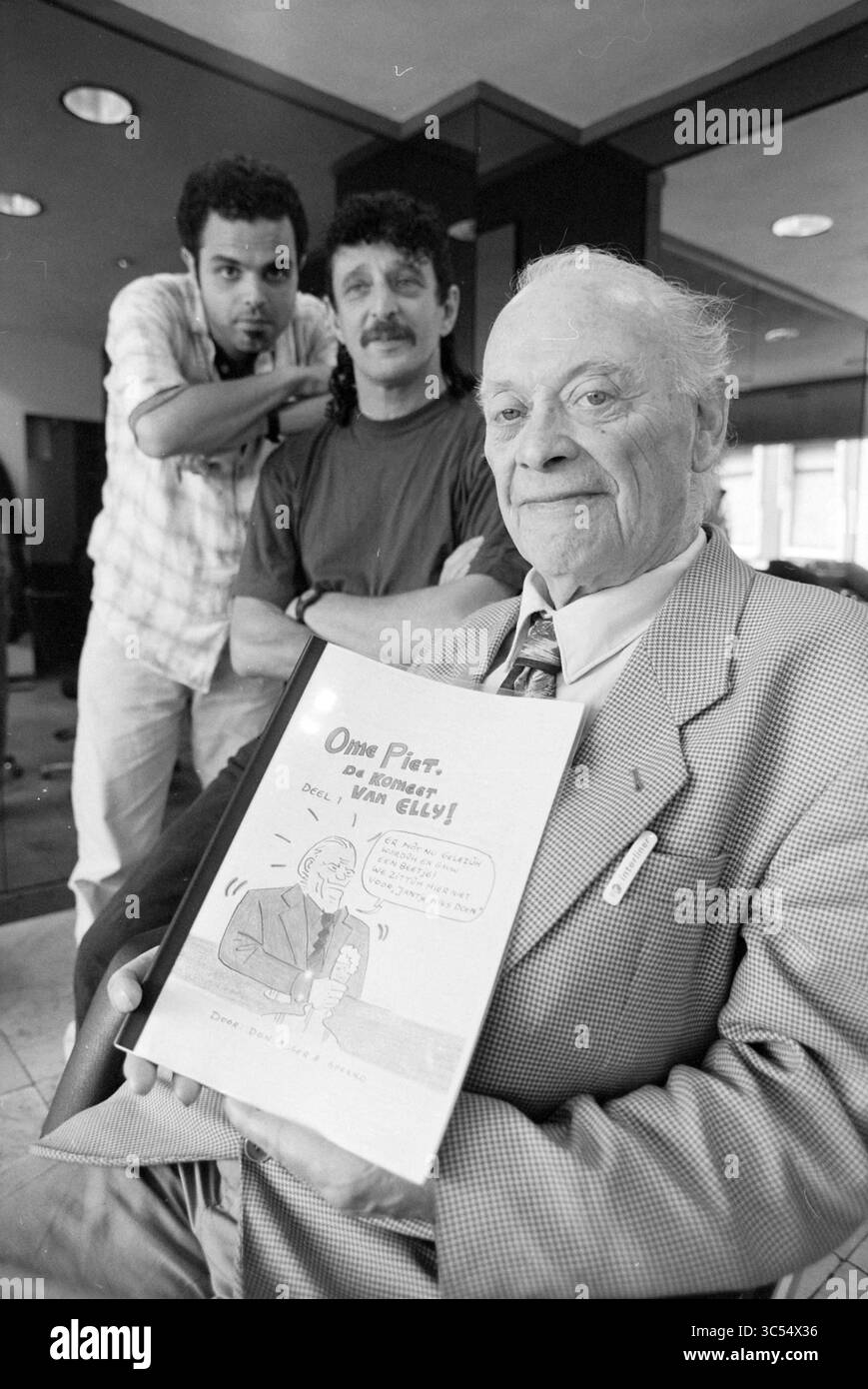 Comic book, Uncle Piet + Makers, Haarlem, Paesi Bassi, 03-06-1996 Whizgle News, Dutch Desk, i Paesi Bassi, 1950-2000 Un uomo anziano distinto seduto in primo piano reggendo un disegno a fumetti, mentre due uomini più giovani stanno dietro di lui, uno con le mani sulle spalle dell'altro. La scena trasmette un senso di cameratismo e nostalgia. Foto Stock