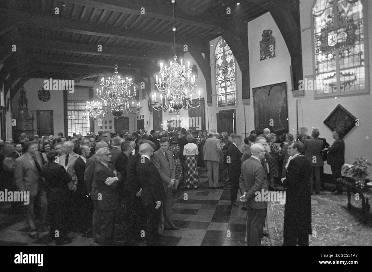 Ricevimento di Capodanno B and W Haarlem, B&W, ricevimenti di Capodanno, 02-01-1976 Whizgle News, Dutch Desk, Paesi Bassi, 1950-2000 Un grande raduno si svolge in un'elegante sala adornata da lampadari ornati e vetrate colorate. Gli ospiti si impegnano in conversazioni, vestiti con un abbigliamento formale, mentre un senso di celebrazione riempie l'aria. Le caratteristiche architettoniche e gli arredi della sala esaltano l'atmosfera sofisticata dell'evento. Foto Stock