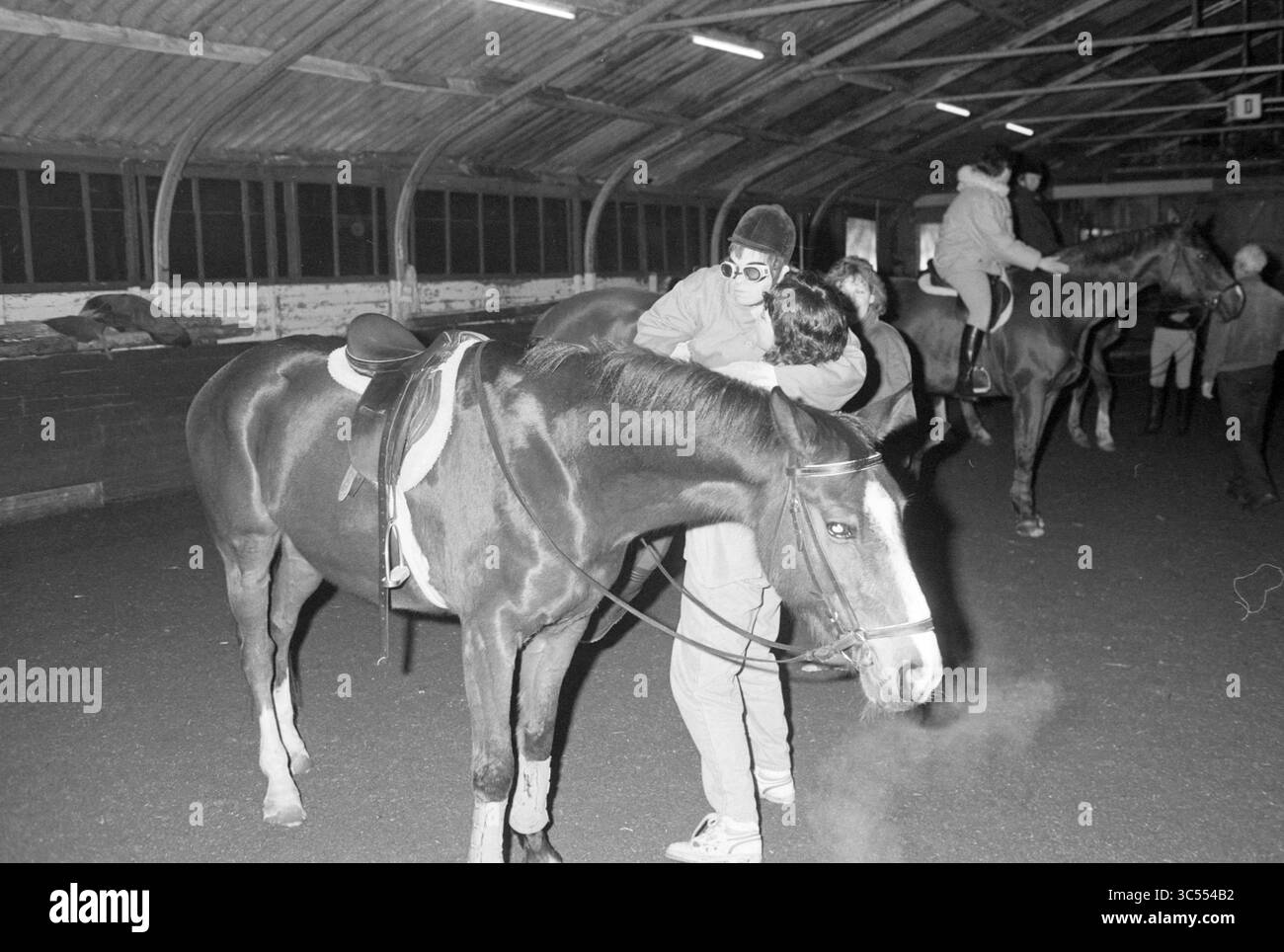 Disable Horse Riding, Hillegom, 28-01-1991 Whizgle News, Dutch Desk, Paesi Bassi, 1950-2000 Una persona interagisce amorevolmente con un cavallo in una spaziosa arena di equitazione al coperto, mentre altri cavalieri si impegnano con i loro cavalli nelle vicinanze. L'atmosfera trasmette un senso di connessione e cameratismo tra esseri umani e animali in questo ambiente equestre. Foto Stock Disable Horse Riding, Hillegom, 28-01-1991 Whizgle News, Dutch Desk, Paesi Bassi, 1950-2000 Una persona interagisce amorevolmente con un cavallo in una spaziosa arena di equitazione al coperto, mentre altri cavalieri si impegnano con i loro cavalli nelle vicinanze. L'atmosfera trasmette un senso di connessione e cameratismo tra esseri umani e animali in questo ambiente equestre. Foto Stock