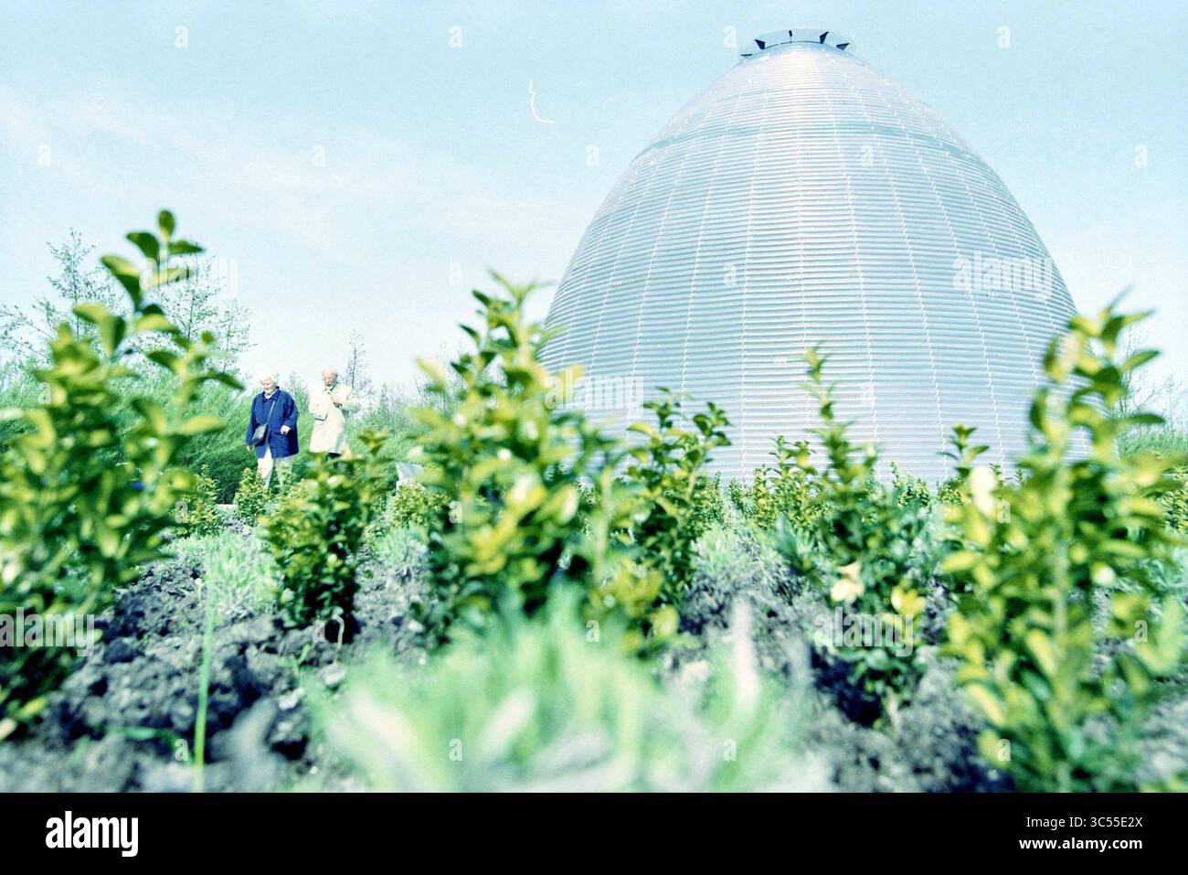 Floriade Silence Center, Vijfhuizen, Vijfhuizen, 22-04-2002 Whizgle News, Dutch Desk, i Paesi Bassi, 1950-2000 due persone si trovano vicino a una grande struttura a forma di cupola tra vegetazione lussureggiante e arbusti bassi, creando un'atmosfera serena che fonde la natura con l'architettura moderna. Foto Stock