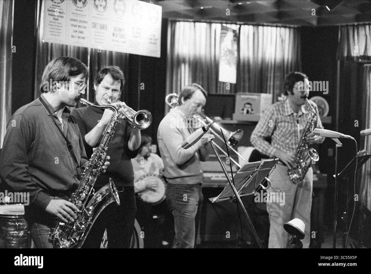 Seth Hot Jazz band, Jazz, 06-11-1977 Whizgle News, Dutch Desk, Paesi Bassi, 1950-2000 Un gruppo di quattro musicisti che suonano con passione i loro strumenti, mostrando una vivace performance jazz. L'ambiente è intimo, con uno sfondo con poster e illuminazione soffusa che aggiunge un tocco di atmosfera. Ogni musicista è concentrato sulla propria arte, contribuendo al suono vibrante dell'ensemble. Foto Stock