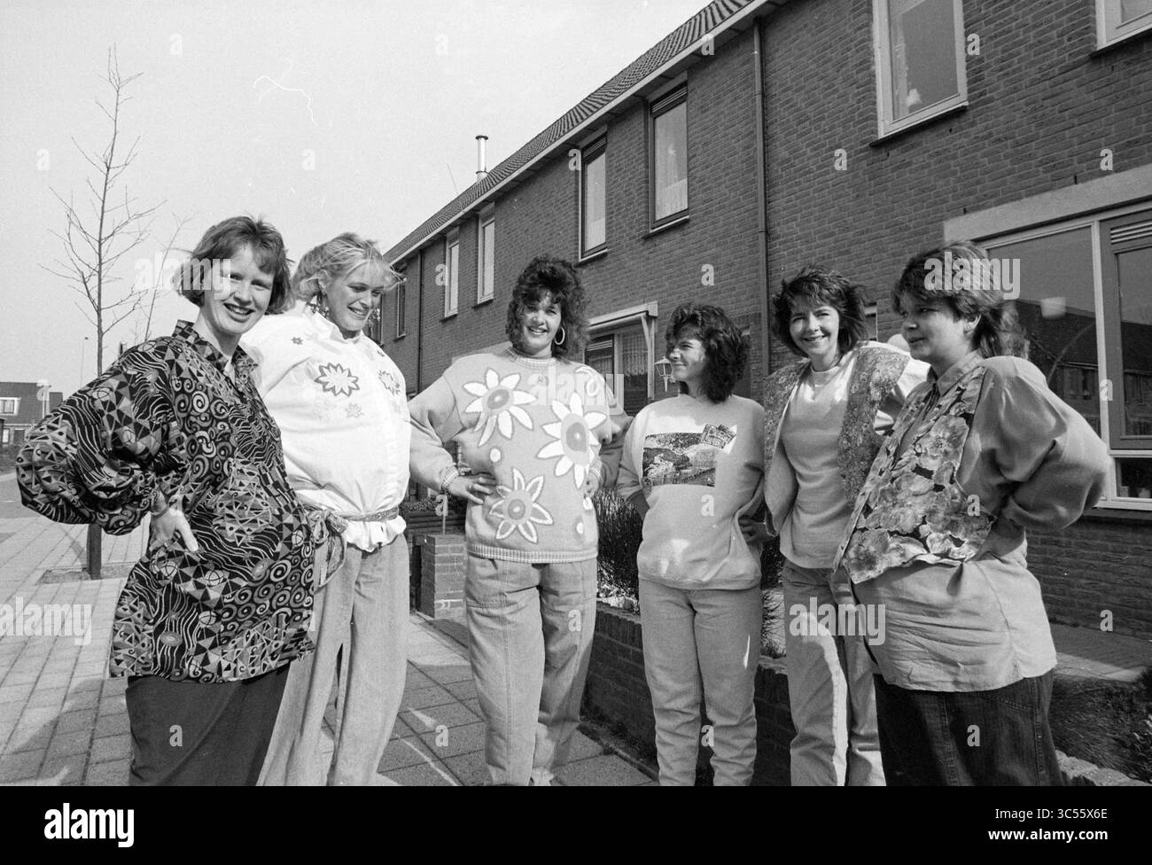 6 donne incinte Velserbroek, donne, Velserbroek, 23-03-1990 Whizgle News, Dutch Desk, i Paesi Bassi, 1950-2000 Un gruppo di sei donne sta insieme su un marciapiede, sorridendo e posando giocosamente. Indossano camicie vivaci e vivaci, ognuna con un design floreale unico. Lo sfondo presenta una fila di case moderne, che enfatizzano un'atmosfera vivace e comunitaria. Foto Stock