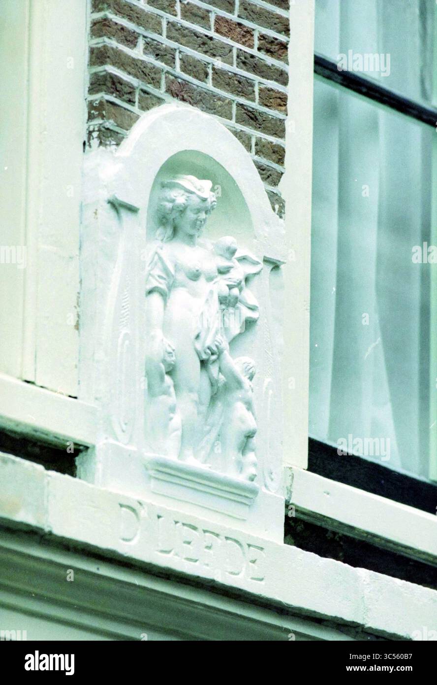 Pietra di Gable, Ridderstr. 22, H'lem, Haarlem, Ridderstraat, Paesi Bassi, 06-11-1996 Whizgle News, Dutch Desk, Paesi Bassi, 1950-2000 Un rilievo decorativo presenta una classica figura femminile circondata da animali, intricati intagliati e adagiati su un muro testurizzato. Sotto la scultura è inciso il nome "D'Leede", aggiungendo un elemento di identità alla mostra artistica. Foto Stock