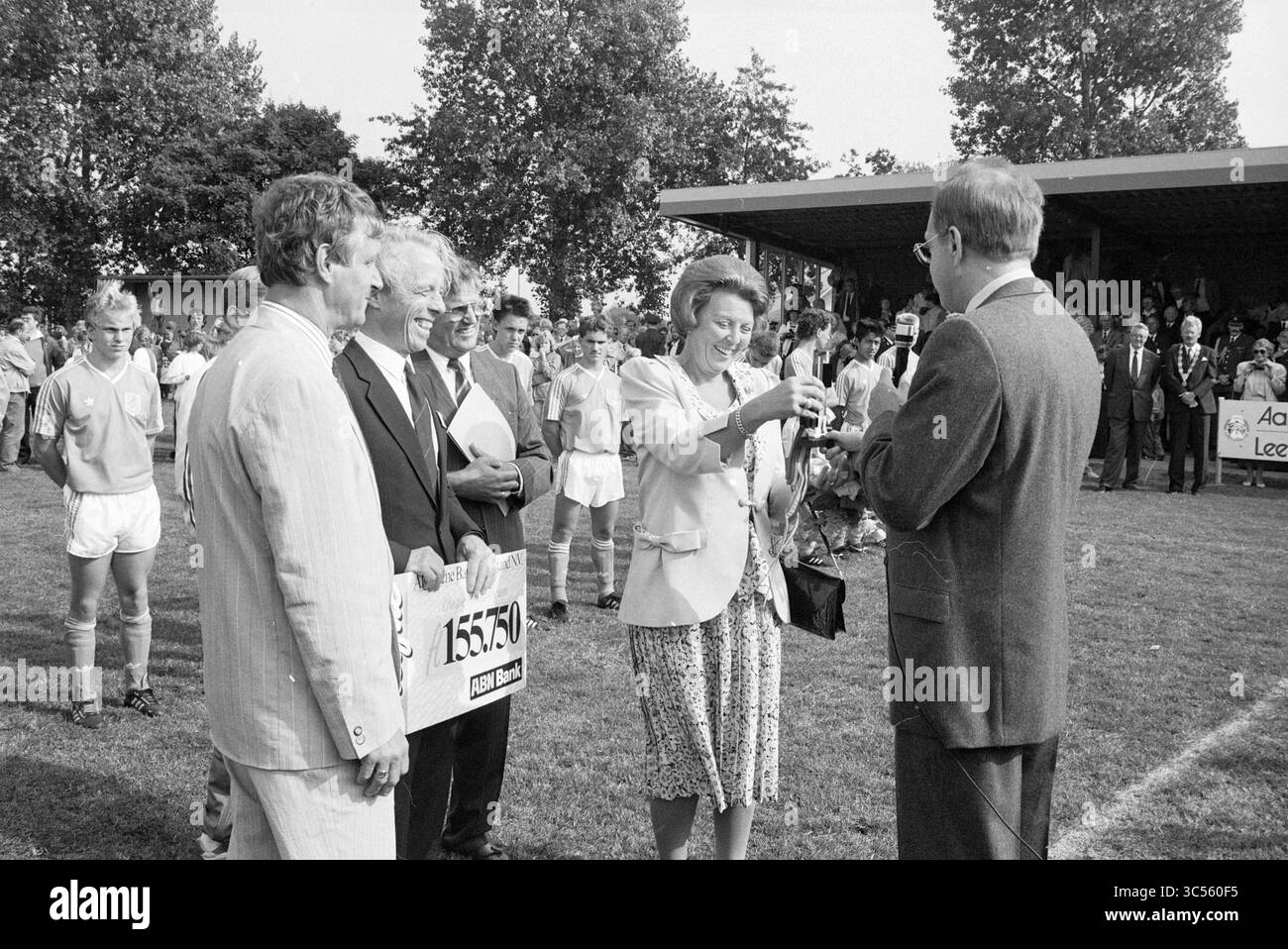 H.M. Beatrix at Swallow Tournament, Driehuis, Royal Recetions and Royal Visits, Sports and Sports week, Driehuis, 09-09-1989 Whizgle News, Dutch Desk, Paesi Bassi, 1950-2000 Un raduno in un campo sportivo presenta un gruppo di individui ben vestiti, con una donna che tiene un trofeo e sorride mentre lo consegna a un uomo adatto. Nelle vicinanze, spettatori e giocatori in equipaggiamento sportivo assistono allo scambio, mettendo in evidenza un momento di celebrazione o riconoscimento in un evento della comunità. Foto Stock