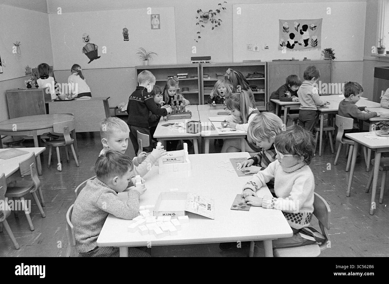 Scuola materna Smedestraat, Schools, Haarlem, Smedestraat, Paesi Bassi, 15-01-1970 Whizgle News, Dutch Desk, Paesi Bassi, 1950-2000 Una vivace aula piena di bambini impegnati in varie attività creative ai loro tavoli. Alcuni bambini sono concentrati sulla creazione di progetti, mentre altri collaborano o giocano nelle vicinanze, mostrando un ambiente di apprendimento vivace e divertente. Decorazioni colorate adornano le pareti, aggiungendo un'atmosfera allegra. Foto Stock