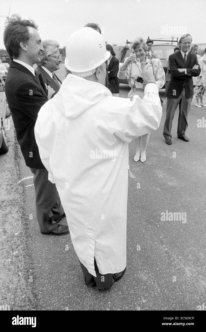 1st pole Wampler Waarderpolder, Haarlem, Paesi Bassi, 10-06-1991 Whizgle News, Dutch Desk, i Paesi Bassi, 1950-2000 Un gruppo di individui si riunisce, con una persona in un elmetto e un mantello bianco mentre si rivolge al pubblico. L'ambientazione sembra essere un evento all'aperto e la folla mostra un mix di reazioni, che vanno dall'interesse al divertimento, mentre si impegnano in una conversazione. Foto Stock