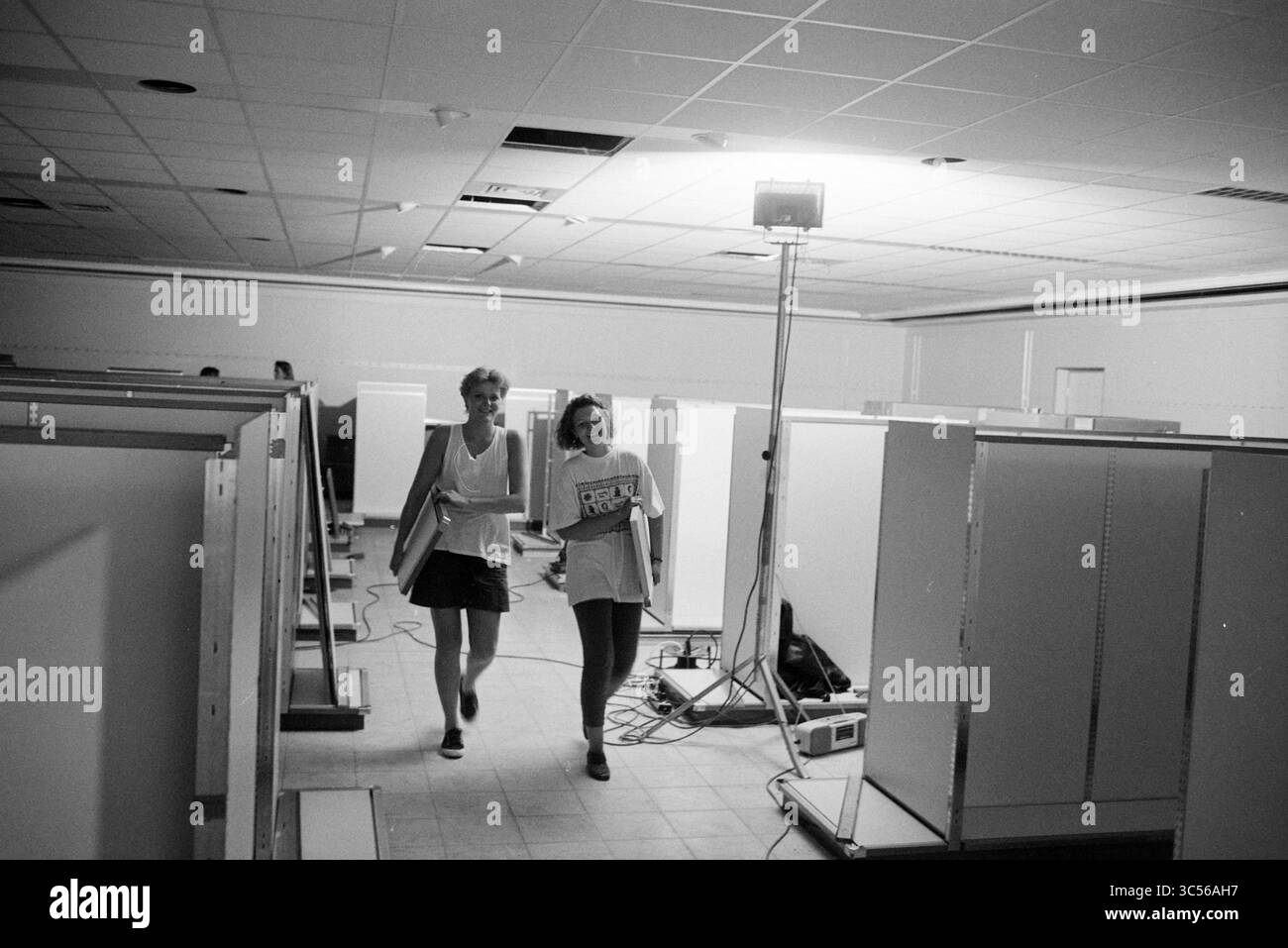 Furniture Hema, Castricum, Castricum, 27-07-1995 Whizgle News, Dutch Desk, i Paesi Bassi, 1950-2000 due persone camminano attraverso un'area spaziosa piena di cabine vuote, che trasportano materiali. Luci luminose illuminano la scena, evidenziando la configurazione organizzata intorno a loro. Foto Stock