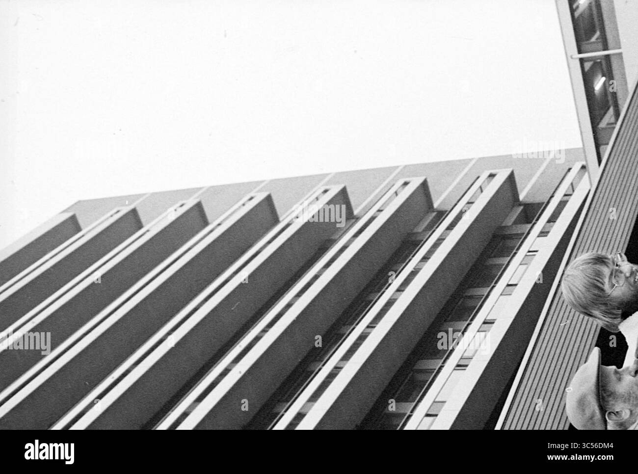 Firma campagna Zeeweg Hospital IJmuiden, ospedali, 23-01-1977 Whizgle News, Dutch Desk, Paesi Bassi, 1950-2000 Una vista dinamica di un edificio moderno con linee angolari suggestive e una facciata prominente, completata dalla presenza di due individui nell'angolo inferiore, apparentemente impegnati in conversazione. Foto Stock