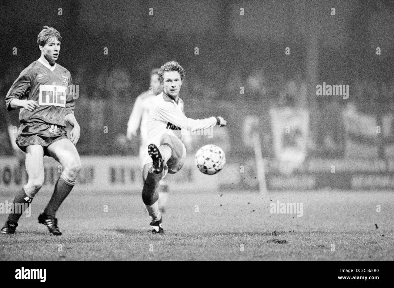 Telstar - Zwolle, 22-11-1991 Whizgle News, Dutch Desk, Paesi Bassi, 1950-2000 Un giocatore esegue abilmente un passaggio sul campo mentre un avversario controlla da vicino il gioco, mostrando l'intensità di una partita di calcio competitiva. La presenza della folla aggiunge un tocco di atmosfera al gioco. Foto Stock