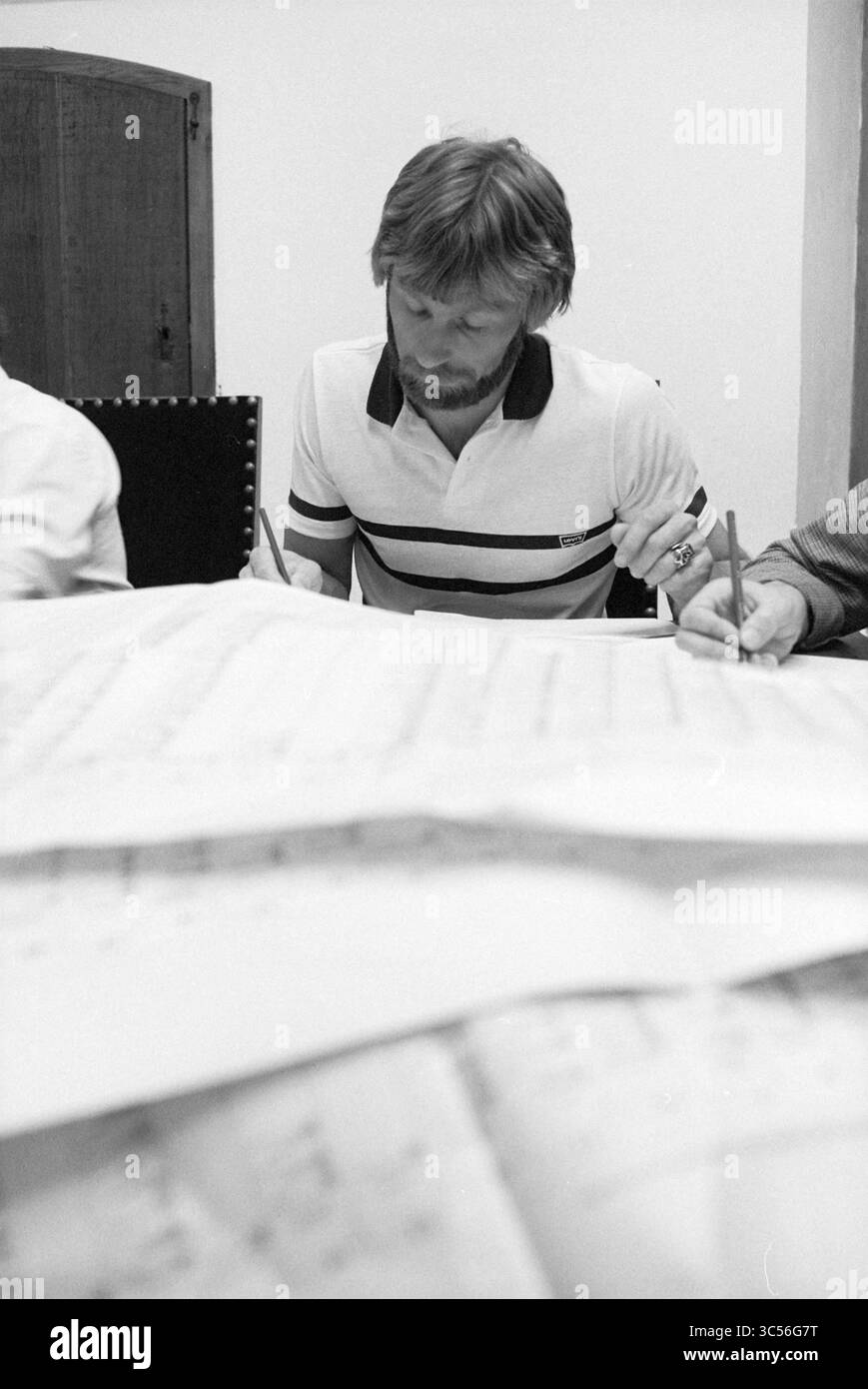 Jaap Brugman conta voti, D'66, 26-05-1981 Whizgle News, Dutch Desk, Paesi Bassi, 1950-2000 Un uomo con la barba si concentra sulla scrittura a un tavolo, circondato da fogli di carta, mentre altri collaborano nelle vicinanze. L'impostazione suggerisce una sessione di brainstorming o pianificazione. Foto Stock