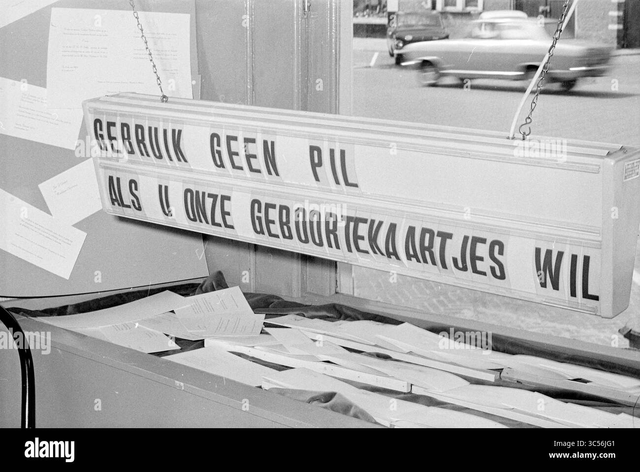 Sign About Birth Annuncements, Signs, 13-06-1969 Whizgle News, Dutch Desk, Paesi Bassi, 1950-2000 Un grande cartello in grassetto consiglia di non utilizzare la pillola se si desidera ottenere i certificati di nascita, circondato da documenti sparsi su un display. Sullo sfondo, passa un'auto d'epoca. Foto Stock