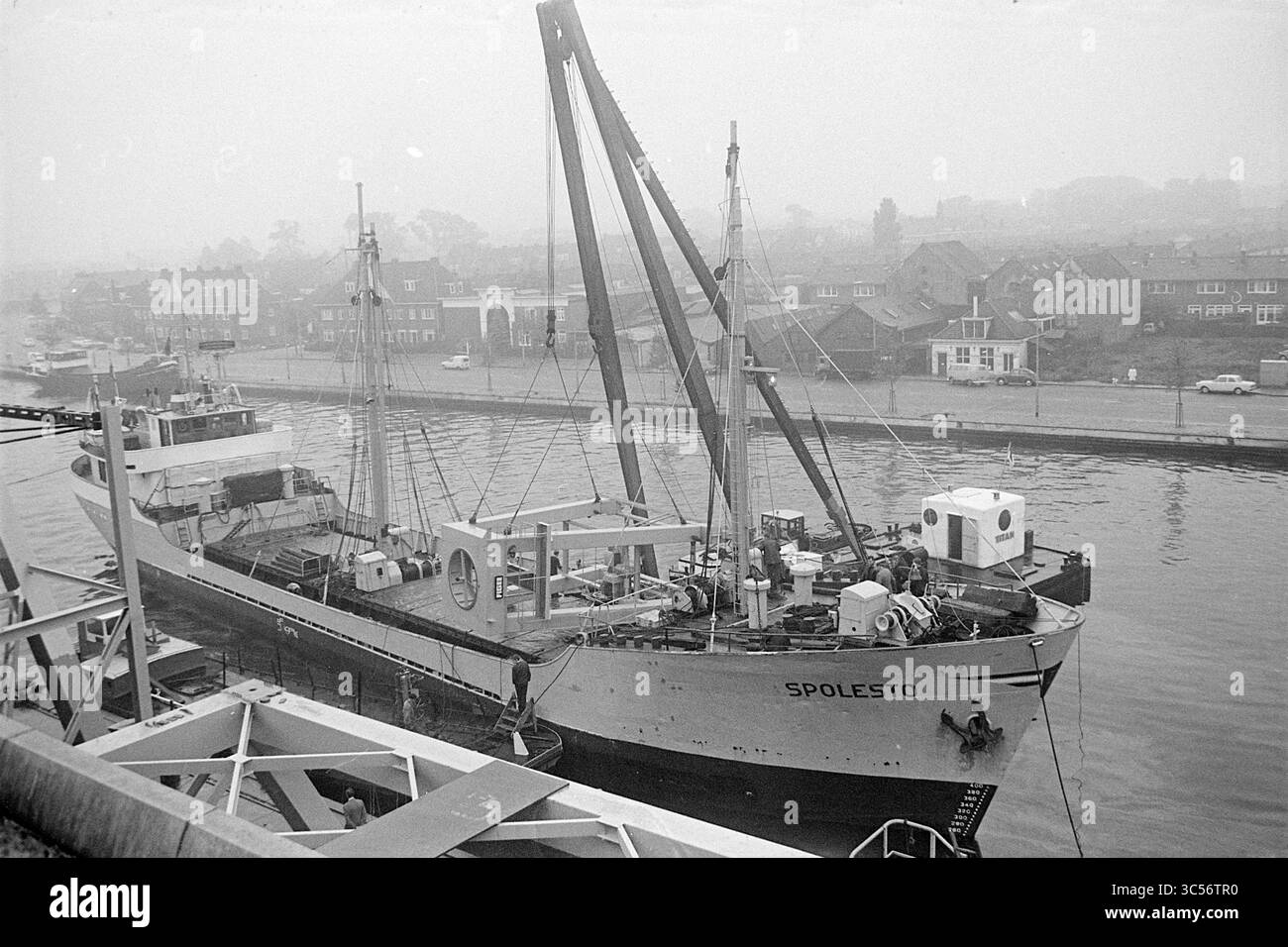 Una struttura galleggiante a balestra è costruita in ferro sulle montagne russe "Spolesto", Haarlem, Paesi Bassi, 04-10-1968 Whizgle News, Dutch Desk, i Paesi Bassi, 1950-2000 Una grande nave da carico denominata "Spoletto" è ormeggiata in un molo, con le sue gru di carico estese. Sullo sfondo, una fila di case costeggia il lungomare, mescolandosi con l'atmosfera nebulosa. La scena trasmette un senso di movimentata attività marittima su uno sfondo sereno. Foto Stock