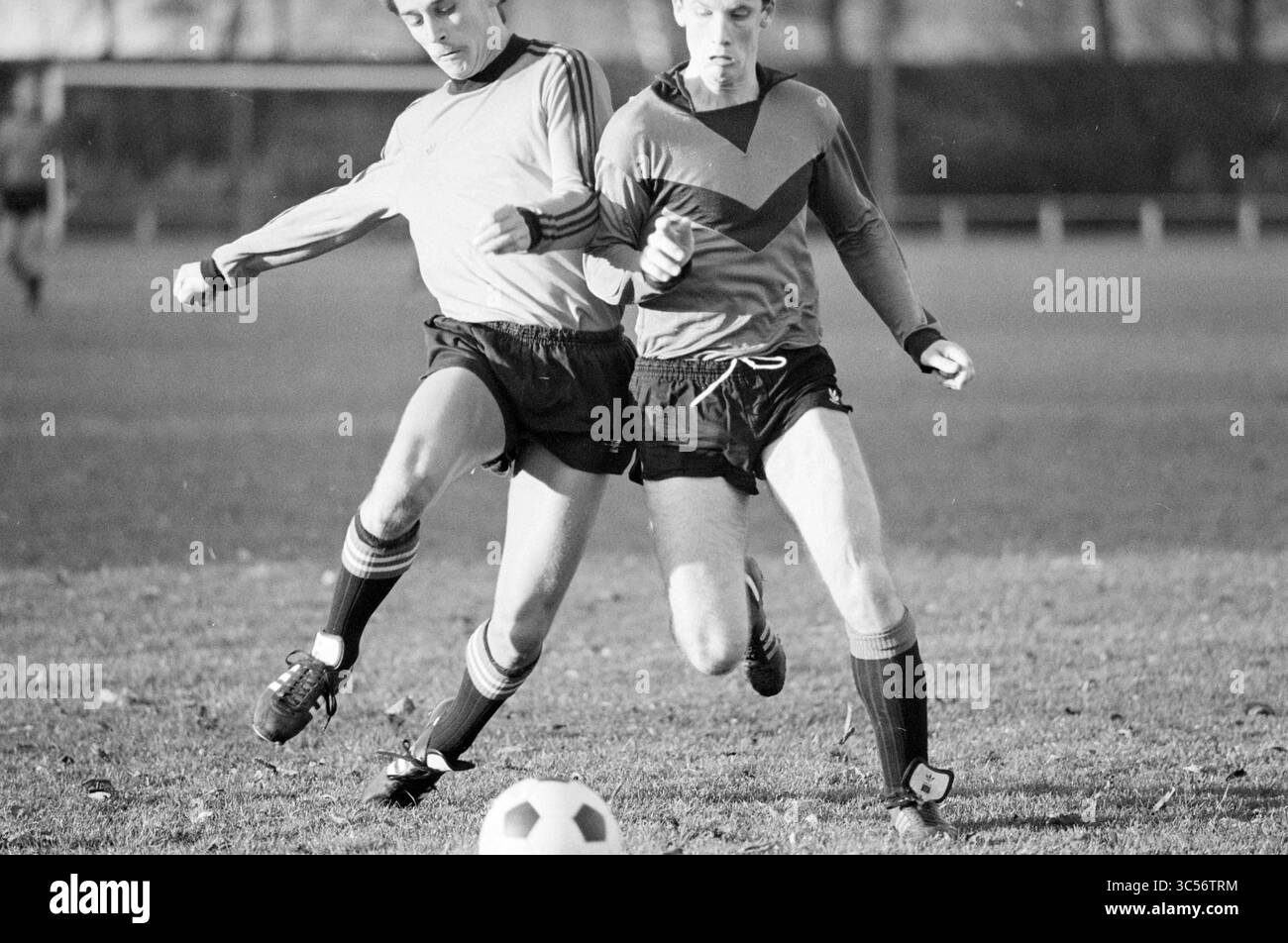 Kennemeren - Vrone, Football Kennemeren, 07-11-1981 Whizgle News, Dutch Desk, Paesi Bassi, 1950-2000 due giocatori di calcio si impegnano in un momento competitivo sul campo, uno che calcia la palla mentre l'altro tenta di intercettare il gioco. Le espressioni focalizzate e la postura dinamica evidenziano l'intensità del gioco. Foto Stock