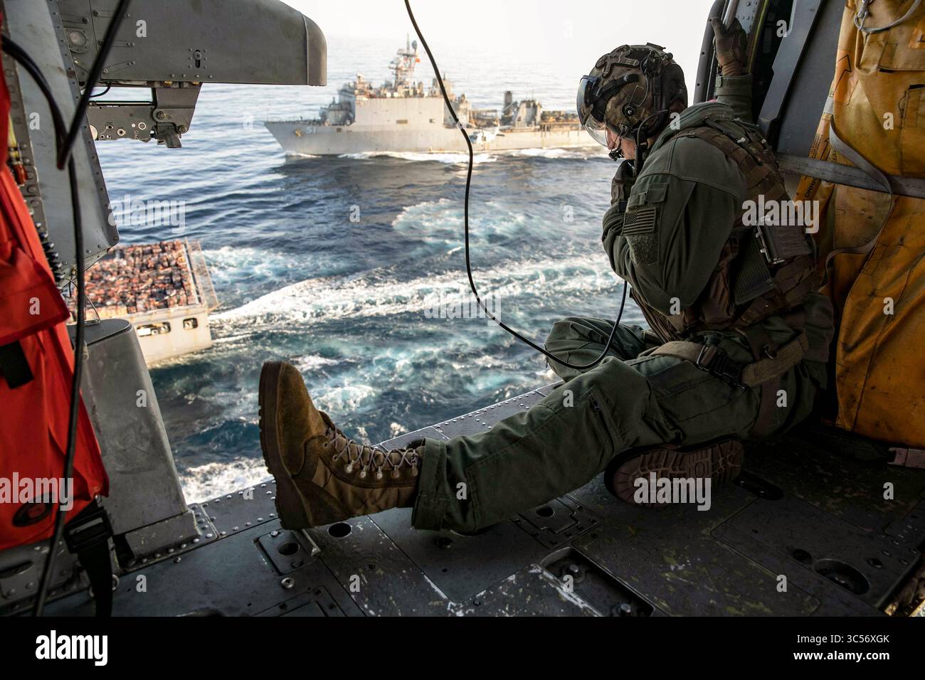 31 dicembre 2019 - Atlantic Ocean - Naval AirCrewman (Helicopter) 2nd Class Matthew Evans, assegnato al Dragon Whales of Helicopter Sea Combat Squadron (HSC) 28, dirige i piloti durante un rifornimento verticale tra la nave d'assalto anfibio classe Wasp USS Bataan (LHD5) e la nave da carico secco e munizioni USNS William McLean (T-AKE 12), 31 dicembre 2019. Bataan, portato a casa a Norfolk, Virginia, sta operando nell'area di operazioni della 6th Fleet degli Stati Uniti a sostegno degli interessi della sicurezza nazionale in Europa e Africa. (Immagine di credito: © U.S. Navy/ZUMA Wire/ZUMAPRESS.com) Foto Stock