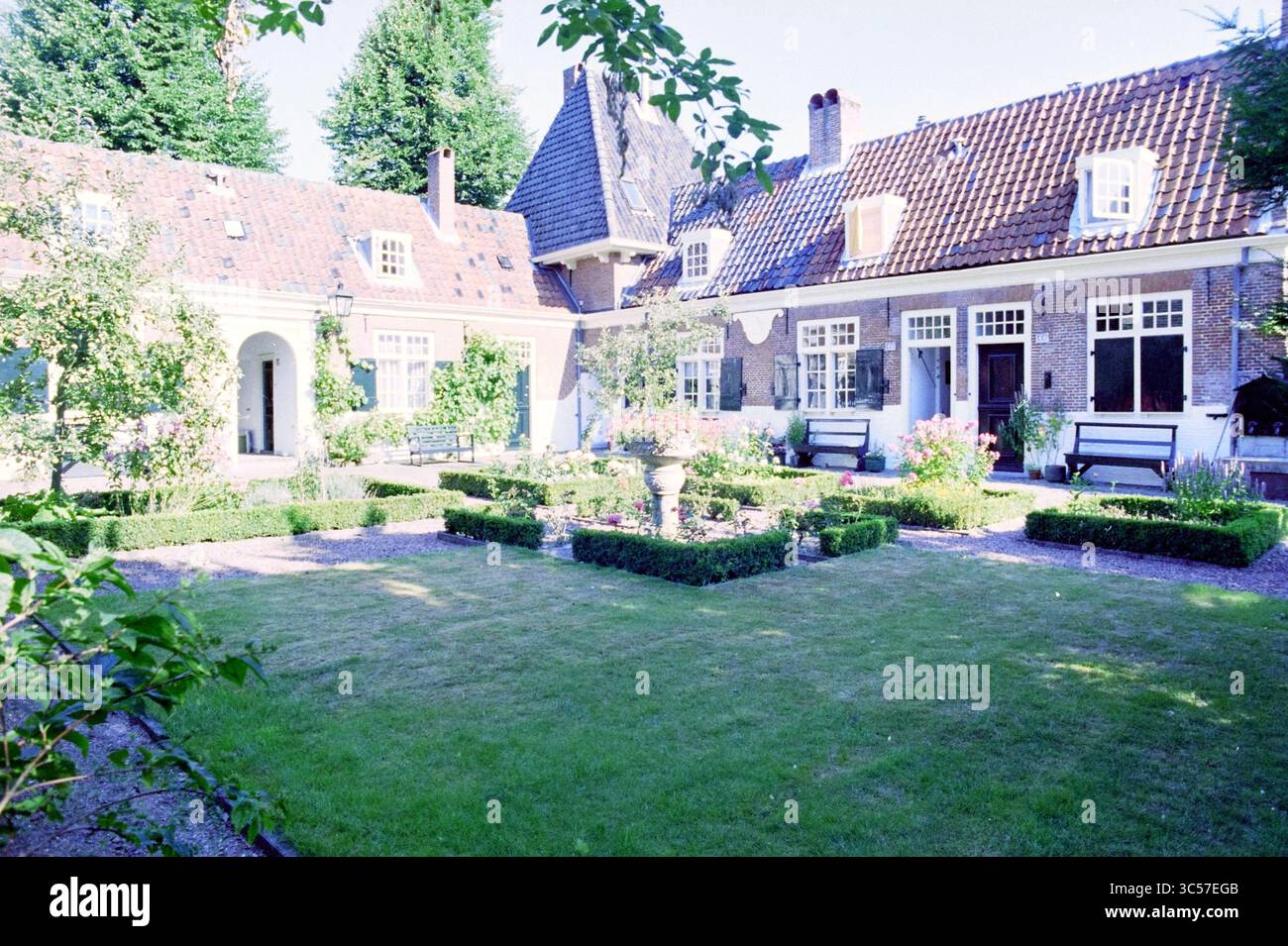 Courtyard of Heythuysen, 09-08-1995 Whizgle News, Dutch Desk, The Netherlands, 1950-2000 Un incantevole cortile circondato da giardini ben curati, con siepi ben rifinite, aiuole di fiori e una fontana centrale. L'architettura elegante sfoggia un mix di design tradizionali e pittoreschi, con accoglienti aree salotto che invitano al relax nel verde. Foto Stock