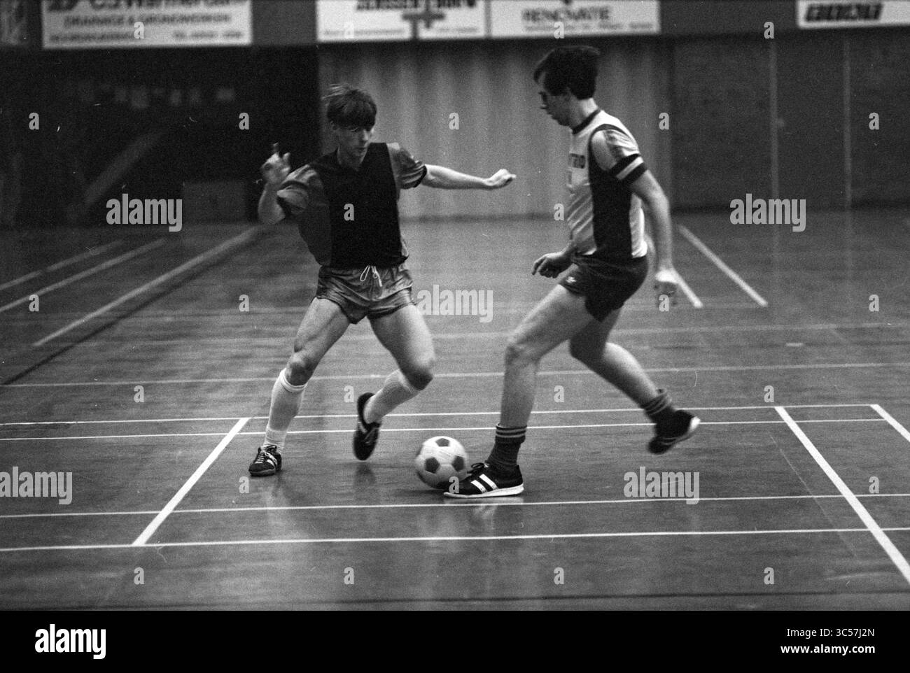 Gractz - Hillegom, Indoor football, 29-11-1982 Whizgle News, Dutch Desk, Paesi Bassi, 1950-2000 due giocatori partecipano a un'intensa partita di calcio al coperto, manovrando abilmente la palla tra loro. Un giocatore tenta una mossa rapida per sfuggire all'altro, che è pronto a bloccare il gioco. La scena cattura l'energia e il dinamismo del gioco, enfatizzando l'atletismo e la strategia in campo. Foto Stock