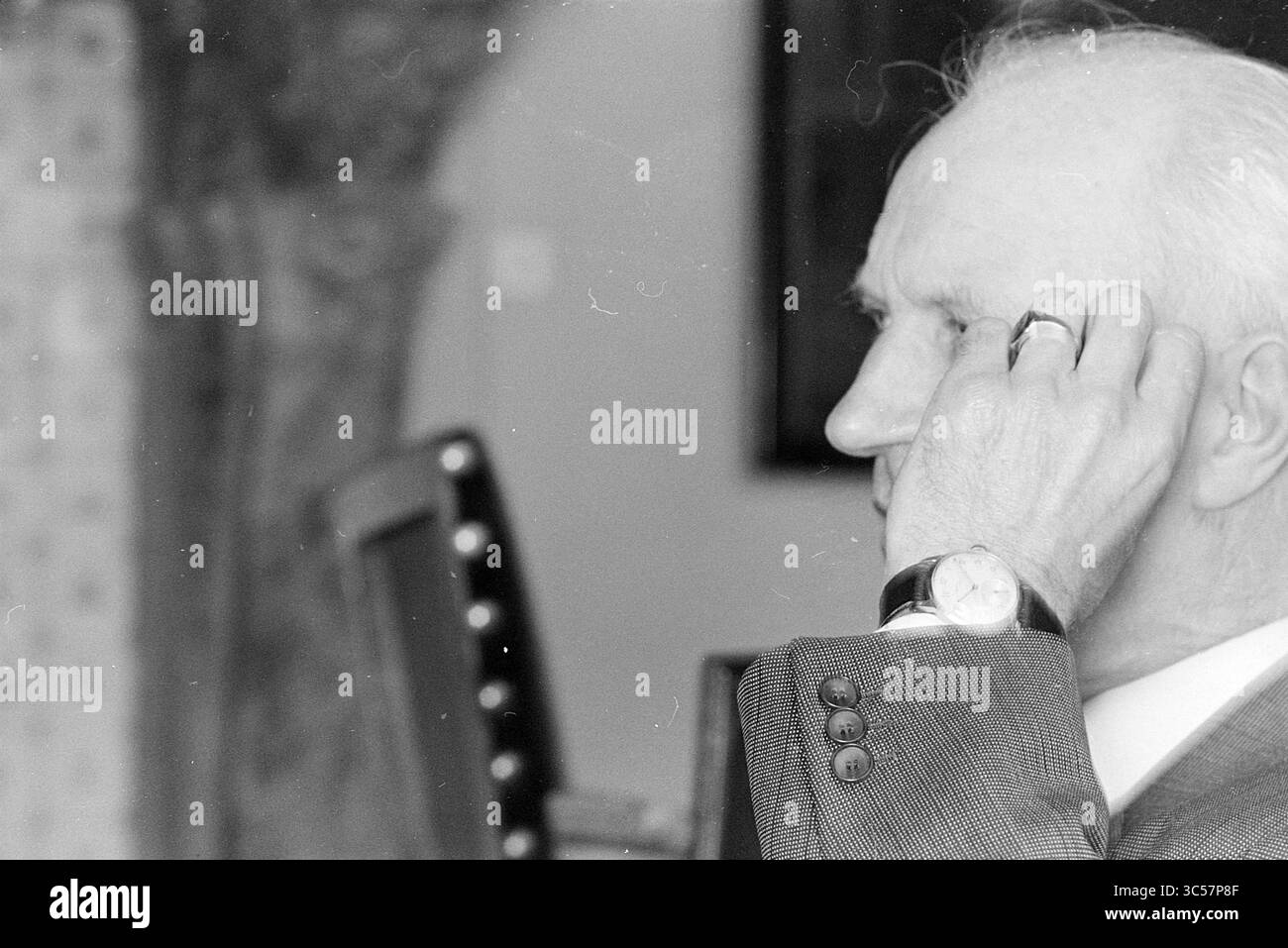 Ritratto di Burg. Cremers, Sindaci, 08-05-1969 Whizgle News, Dutch Desk, Paesi Bassi, 1950-2000 Un signore anziano e distinto siede con un'espressione premurosa, la mano alzata all'orecchio come se ascoltasse intensamente. Indossa un abito classico e un orologio, trasuda un'aura di raffinatezza e contemplazione. Foto Stock