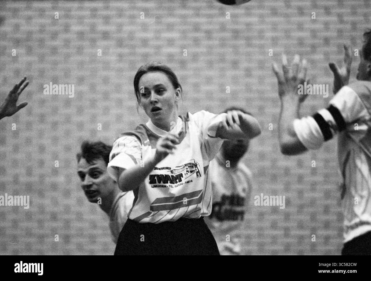 Korfball, DKV - Vlaardingen, 03-02-1995 Whizgle News, Dutch Desk, Paesi Bassi, 1950-2000 Un'atleta in azione, che passa abilmente una palla in mezzo a una scena dinamica con compagni di squadra e avversari. L'intensità del gioco è palpabile poiché tutti si concentrano sul gioco. Foto Stock