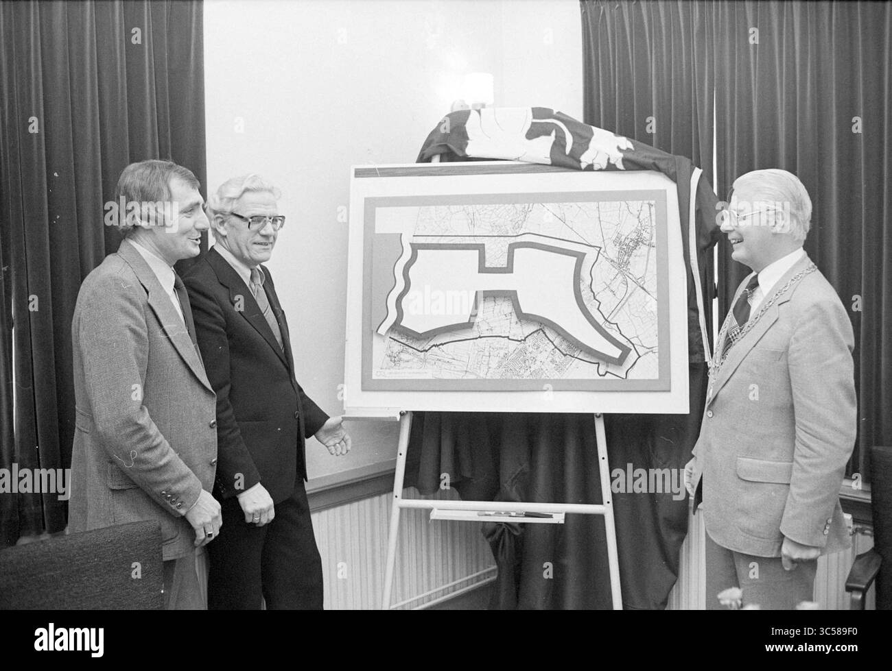 Informazioni sulla vignetta B'wijk, Beverwijk Municipal Council, 20-10-1978 Whizgle News, Dutch Desk, Paesi Bassi, 1950-2000 tre uomini sono accanto a una grande mappa visualizzata su un cavalletto. La mappa delinea un'area specifica, e un panno è avvolto su qualcosa dietro di loro. Sembrano impegnati in una conversazione, con un senso di significato che circonda la presentazione. Foto Stock