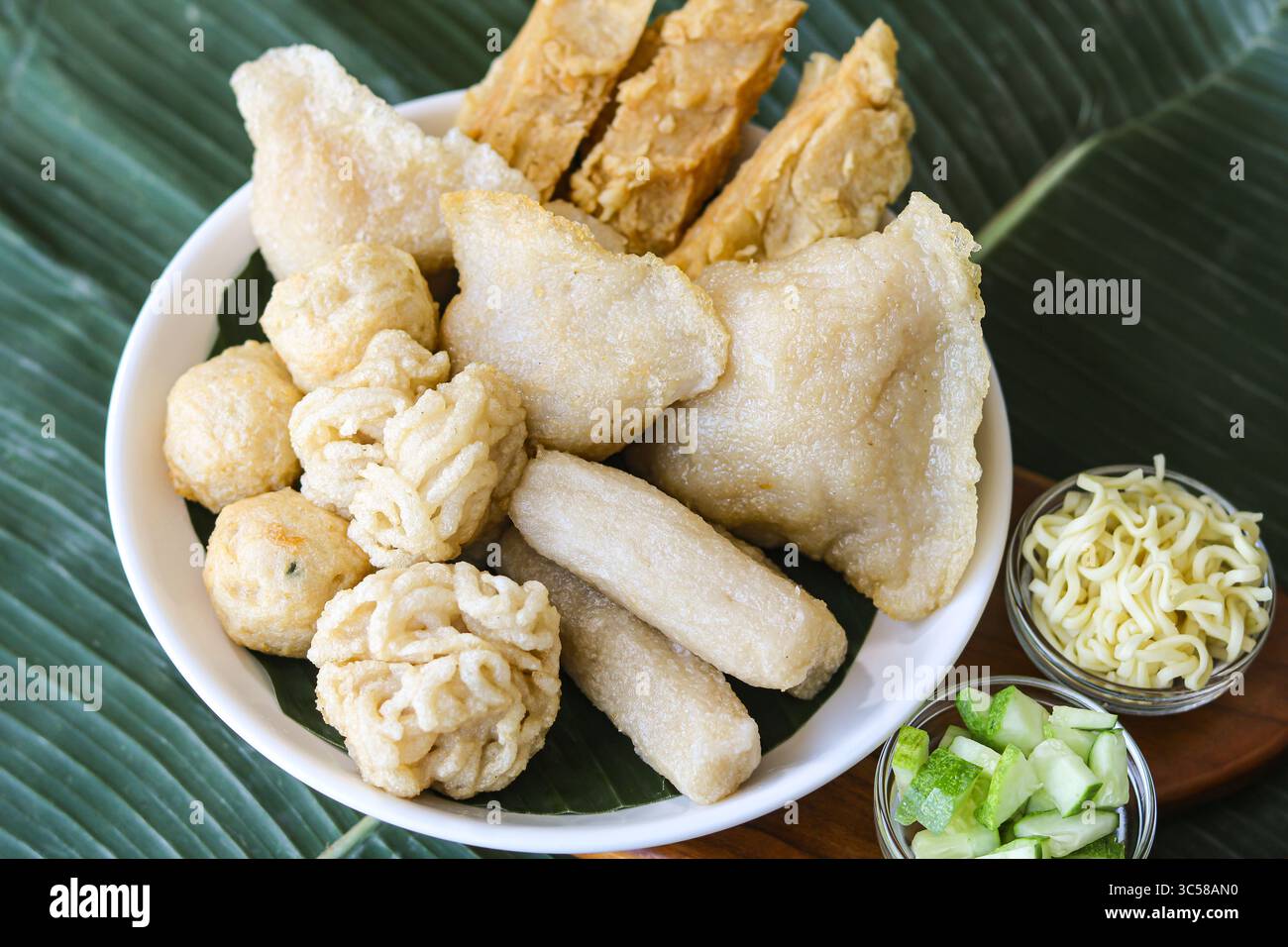 Un generoso piatto con un assortimento di Pempek (o Empek-Empek), un tradizionale piatto indonesiano di torta di pesce di Palembang. Foto Stock