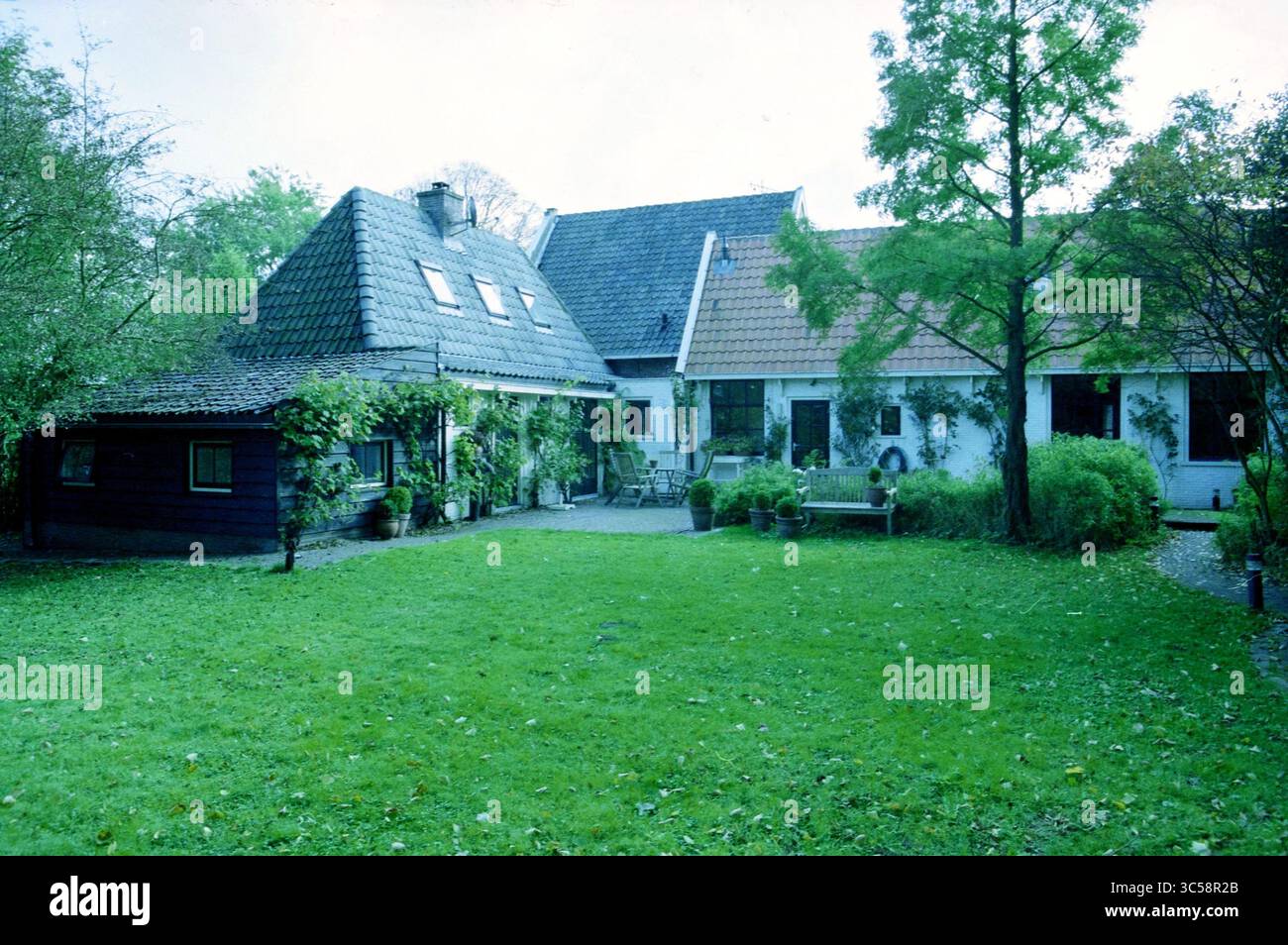 Farm, Middenduin, Santpoort, Santpoort, 19-10-2003 Whizgle News, Dutch Desk, Paesi Bassi, 1950-2000 Un affascinante albergo caratterizzato da una combinazione di tetti inclinati e architettura moderna, circondato da vegetazione lussureggiante e giardini ben tenuti. L'ambiente naturale esalta l'atmosfera serena, perfetta per il relax. Foto Stock